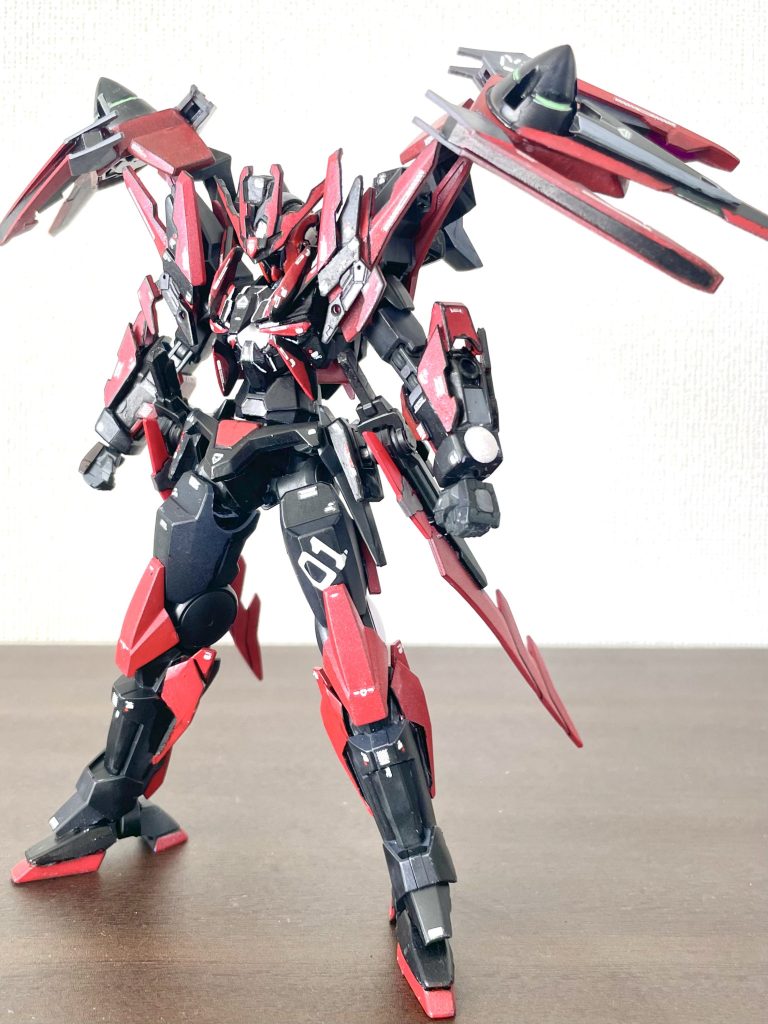 機体名 ガンダムダブルオーバンデット本機はガンダムメタバース空間で活躍するトッププレイヤーの1人、ビルドダイバーズのリクが持つ卓越したガンプラ製作技術とプレイスキルに嫉妬したとあるプレイヤーによってカスタムされたダブルオーガンダムである。