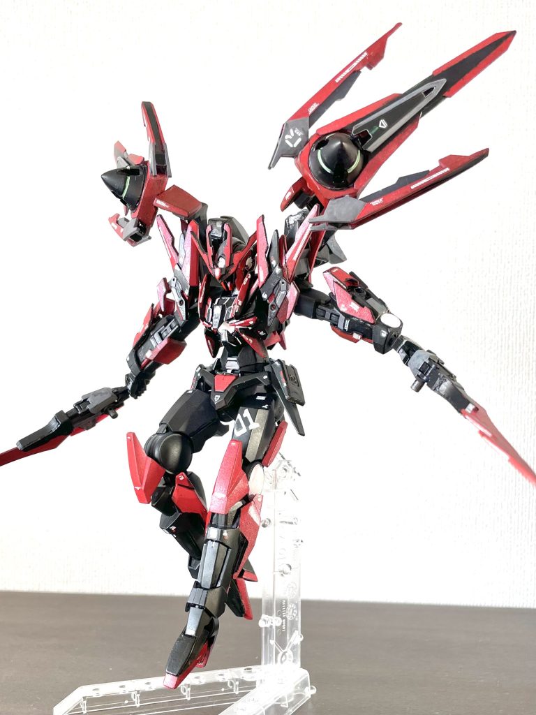 その嫉妬心故か本機はメタバース内でリクが使用する機体ダブルオーダイバーアークの姿を模して製作された。さらに製作者本人もリクと同じアバター、名前の別アカを用意してリクになりすましており、その姿でPK(プレイヤーキル)やマッチング部屋荒らし、トレインなど数多の迷惑行為をすることで裏からリクの印象操作を行っている。