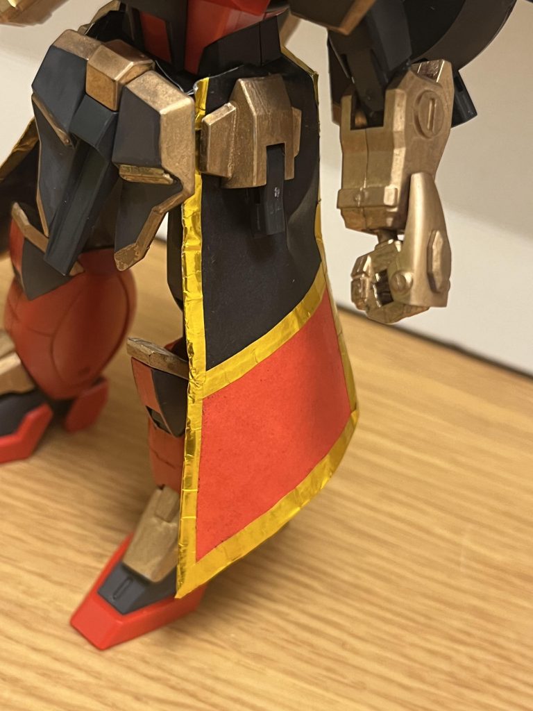 各種機能・特殊能力モビルトレースシステム本機に採用された操縦システムであり、本来はMF(モビルファイター)専用として使われている。パイロットが「ファイティングスーツ」と呼ばれる特殊スーツを着て動く事で、パイロットの動きをそのまま機体がトレースして動く。人間の骨格と機体の構造は完璧に一致する訳ではないため、機体側が対応しきれない複雑な動きをとる場合は、操縦者の感情や脳波を機体側にフィードバックする事によって、補完する。従来との相違点として、本機のファイティングスーツは、ヘルメットを通じてパイロットの神経と本機の全システムを直結させる為、従来を遥かに上回る反応速度を誇る。また、装着時の多大な圧力が95%にまで軽減されている他、素肌に着用させずとも伝導率が極めて高く為、着用時に裸体になる必要性も無くなっている。ただし、動きのみならず、本機が受けたダメージと痛み、電位差、重力加速度などの全ての体感覚がファイティングスーツを通して、操縦者に伝わるようになっており、本機の防御力の高さから通常のビームライフル程度ではダメージは発生しないものの、防御力の許容量を超えた場合はダメージを受けてしまう。アルテマローブ両腰に装備された専用ローブ。電磁偏向シールドを常時展開しており、敵のビーム攻撃を曲げて無効化できる他、本機が直接発射したビームの軌道を屈折・偏向できる。また、簡易的な重力操作機能が備わっており、このローブ単体でも推進力を用いず飛行可能となっており、本機の持つ高い機動力と併せて、旋回性能の補助としても機能する。※このローブも折り紙で作りました。リガードアイ本機全身の装甲各部に内蔵されたカメラで、リアルタイムで情報を更新し続け、全周囲を隈無く確認できる他、本機の桁違いのエネルギーを受けて、高圧縮ガンマレイによる高出力ビームを放出可能となっている。このビームの威力は凄まじく、1発でナノラミネートアーマーをも貫通するほど。時間操作能力本機最大の切り札にして、文字通り時間を操る特殊能力である。時間操作を可能とするクロノスフリーダムガンダムとの相違点として、こちらでは加速と逆行を可能とする。時間加速対象となる存在の時間を加速させる。本機(及びパイロット)の時間だけを速めれば、周りが超スローモーションになるほどの超高速移動をも可能とする。そのスピードは亜光速レベルで動くMSにも匹敵するほど。さらに、敵に直接触れる事で、MSや戦艦などの機動兵器をエネルギー切れに追い込んだり、生物や無機物を問わず物体を急速に腐食させる応用も可能。時間逆行対象となる存在の時間を逆行させる。宇宙空間で使用してしまえば、対峙するMSそのものを喪失させ、宇宙戦闘服を着たパイロットを丸腰にして、即死させてしまう。仮に地上で使われた場合でも、その後に敵からの攻撃に晒される為、対峙する相手からすれば「使われたらアウト」に等しい。逆に本機(及びパイロット)に対して使用すれば、損傷やダメージそのものを無かった事にできる為、実質的な再生能力としても機能する。弱点あくまで体感時間を操作するだけなので、人間の精神や記憶には干渉しない他、特殊能力への耐性を持つMSには通じない。