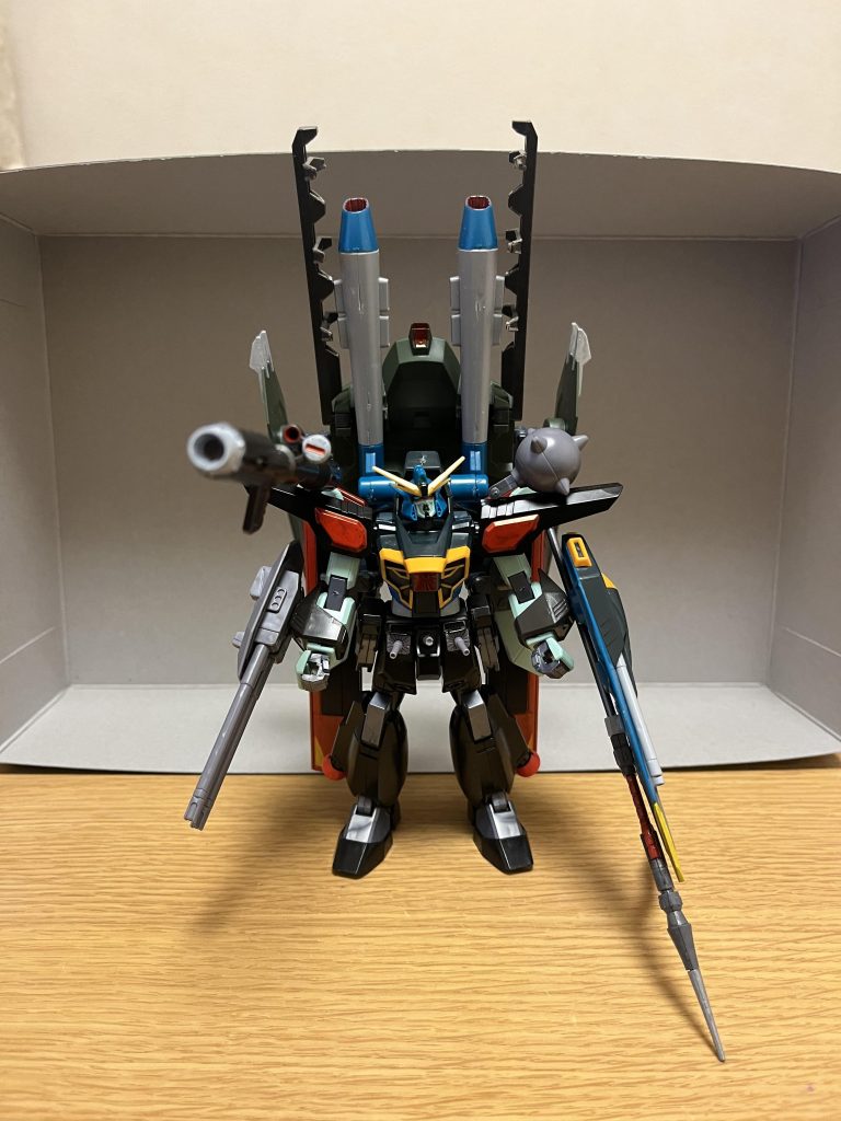 特殊能力※これらの特殊能力は、「特捜戦隊デカレンジャー」に登場する怪人・スペキオン星人ジェニオが設定モチーフになっています。光変換能力本機を光に変換して、光を反射する物質の中に潜り込み、その中を自在に移動できる特殊能力で、オリジナルのDG細胞によって発現した能力でもある。光を反射する物質は、金色のワッペン、ファスナー、人間の瞳から涙、さらには水滴ですらも含まれているので、光を反射する物であれば、金属から布まで本当に何でもあり。要するに、自らを光に変えて、鏡やガラスに潜り込み、鏡の中の世界を瞬時かつ自由に活動できる能力である。光に変換した状態では、基本的に敵からの攻撃は当たらず、逆に本機からも攻撃不可能だが、文字通り光の速さで移動できる為、亜光速レベルで動くMSの攻撃をも回避可能とする。ただし、長時間本機を光に変換し続ける訳ではなく、鏡やガラスに潜り込めなければ30秒経過後に実体化してしまうため、この能力の使用条件として光を反射する物質が付近に存在する必要がある。ミラーリフレクトレイ光変換能力の応用して開発された「自分以外の物質をも光に変えて、鏡の中に閉じ込める」というシステム。本機のスキュラ発射口周辺が鏡を展開しつつ、近くの光を反射する物質と組み合わせる事で、鏡の無限回廊を作り出し、その鏡から放つ光線によって、対象を光に変えて、そのまま鏡の中に送り込んで閉じ込める。対象は、人間やMSどころか戦艦でさえ閉じ込められる。鏡の中では、本機(とパイロット)のみが移動可能なのに対して、逆に閉じ込められた対象は、基本的に鏡の中を移動不可能。弱点として、合わせ鏡の無限回廊を作るには、光を反射する物質(鏡やガラスなど)が必要であり、胸部の鏡だけでは発動が不可能。そして胸部の鏡が破損されれば、鏡の中に閉じ込めた対象は全て解放される。一応、スキュラの発射口周辺への設置が考慮されている為、鏡自体の耐熱性は極めて高く、弱点の箇所としては耐久性が優れているものの、大質量兵器や凄まじい攻撃力を有するMSの打撃には耐えられない。また、特殊能力への耐性を持つMSを光に変換する事は不可能。