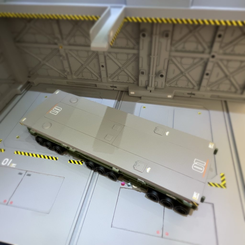 俯瞰からファーストガンダム の1話に出てきたガンダムトレーラーを参考にしてます。デッキ部にハッチ形状のディテールアップパーツを設置&水転写デカールを貼って情報量アップをしています。