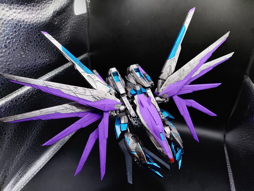 ◯MA形態(超遠距離狙撃モード)本機最大の特徴の形態である、拠点殲滅用の射撃形態です。機体そのものを射撃武器に変形した形態で、先端からジェネシスレイと呼ばれる兵器を展開し、超遠距離から射撃をおこないます。巨大兵器ジェネシスを小型化し、MSが装備できる用に改良されたもので、ジェネシスと同様、物体を振動させて内部から破壊するため、防御不可避のウェーブビームを放ちます。