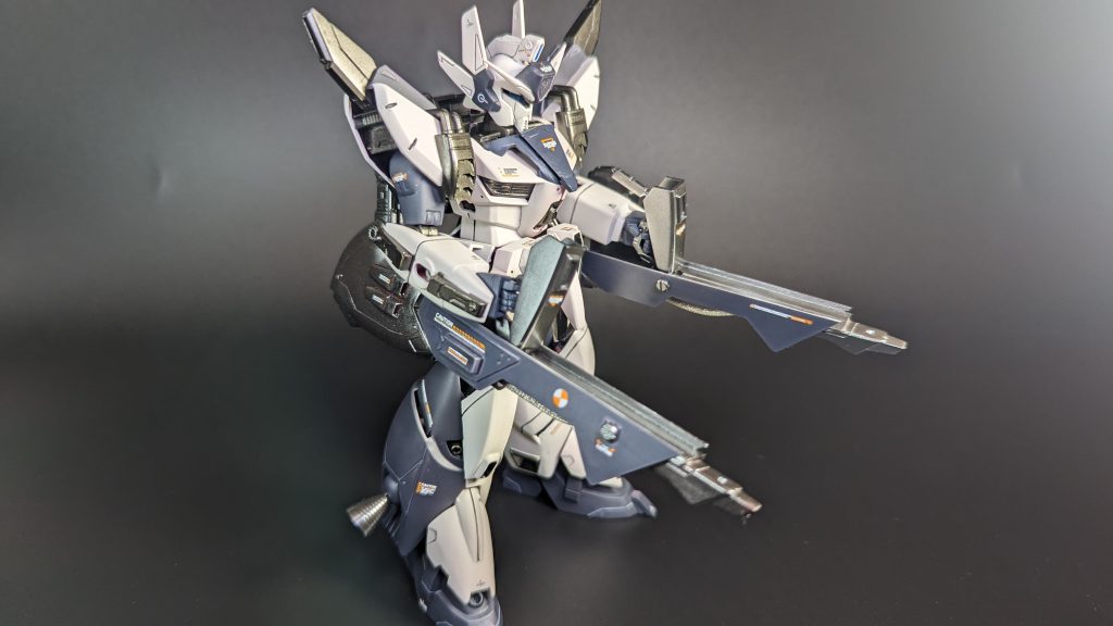 ちゃんと構えることができるよう、何度も位置調整を行いました。浮遊感のあるポージングを取るともっと映えそうですが、別の改修が必要になるので今回は諦めました。肩の側面は内部が丸見えだったので、ちょっとしたプラ板工作で埋めました。足の部分は本来は全部同色ですが、先に作ったダギ・イルスと配色をあわせるため色を変えて別装甲のように表現しています。