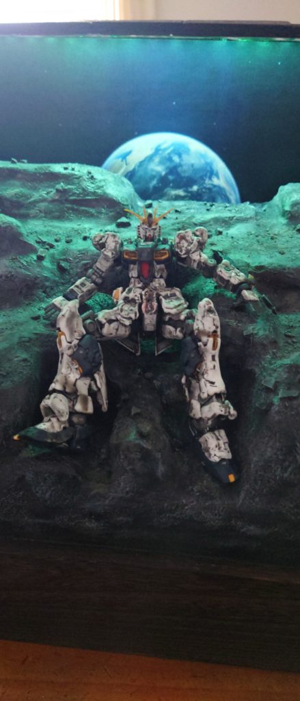 前回、製作しましたTwilight AXISのνガンダムバージョンです(笑)今回はサザビー以上にダメージ加工を行いました。摩擦熱で周りのMSが爆創する中、νガンダムも想像以上に機体にダメージを負っているだろうと脳内妄想で加工しました。照明のグリーンはサイコフレームの光をイメージです。