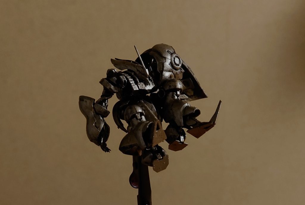 改造して、黒サフ→銀塗装した状態です。流し込み接着剤を使ったので、基本もぎ取るようにパーツを外しています。右腕はバインダーを外して腕の向き、指の角度をネジって変えています。アーティファクトのプラは強度があるのでネジっても壊れません。足は右足をまっすぐ、左足は関節で切り離して角度を変えています。背部のファンネルコンテナは泣く泣くオミット。左腕は手前のバインダーを切断し、前腕の外装を剥いだ上で、コードやアンテナ?類を下方向に垂らしています。顔はタガネで適当に傷を入れて、胴体の出っ張りを外しています。フロントスカートは劇中だとキュベレイと同型に見えたので交換。少し浮かせるため、切り離した胴体の出っ張りを下に仕込んでます。