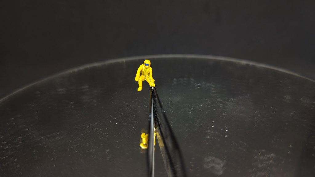 医療班が屈んでF91の頭部に掴まっている時ですね。右手を切り離してくっつけ、下げています。