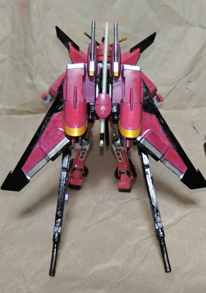 『スペランツァジャスティスガンダム』型式番号:ZGMF-X99Aジャスティスガンダムの後継機開発には∞とは別の開発プランが存在されており、これは当時のプラント最高評議会議長パトリック・ザラに関わった開発チームが極秘に進めていたジャスティスの本来の後継機……という設定で考えたガンダムになります。ジャスティスを超える高い機動性に加え、地球軍から奪った『ブリッツ』、『バスター』の能力をそれぞれ受け継いでいる。本来ならば地球での戦闘データを揃えれば開発を進める予定だったところ、アスラン・ザラの裏切りによって彼にジャスティスをそのまま奪われてしまったことで開発されなかったことも理由の一つで、他にも当時の技術では開発不可能なギミックもあったこともあり、最終的にペーパープランで終わってしまった悲しき機体。設計にはブリッツガンダムのパイロット『ニコル』の父である『ユーリ・アマルフィ』が一番関わっており、この機体にはブリッツに搭載されていたミラージュ・コロイドも備わっている。父親にとって、息子の想いを載せた機体だったとも言える。この設計データは数年後、クライン派が入手して∞ジャスティスとして生まれ変わった……という流れです。そんな機体ですが、時空転移で各世界を救うクロストラベラーのメンバーであるメモリー・カロウが苦労の末、その設計データ及びジャスティスの戦闘データを手に入れたことで開発を叶えた。アスランをライバル視するアース・ザランの新たな機体として譲渡。名前の由来は『ザフトの希望となる正義』という祈りを込めている。最大の特徴は背中に装備された専用のファトゥムにある。またイージスのデータも加わっている為、MA形態に変形することができる。動力源は∞ジャスティスとは別の新技術を使ったNジャマーキャンセラー搭載核エンジンで、パイロットを気絶する程の高いスピードを生み出す……という設定です。