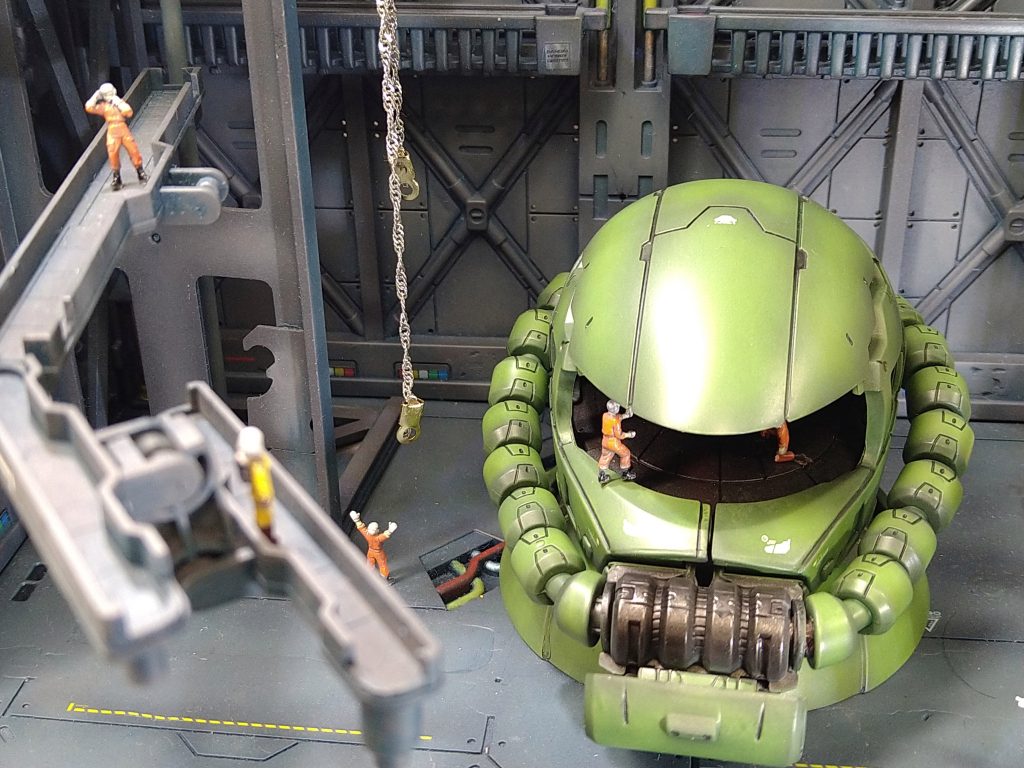 写真は昨年最後に息抜き感覚で塗装したガシャポンのザクヘッドになります。素材がABSでしたので少々気をつかいながら黒サフ立ち上げからのザクグリーン塗装になります。普段はＨＧスケールばかり作っていましたので塗面がかなり大きく新鮮な気持ちでエアブラシ塗装が出来ました。モノアイは銀シールの裏打ちをしたＨアイズの定番工作です。他は墨入れして軽く緑系でフィルタリングをかけてデカールの色味を抑えました。コーションデカールは1/144相当の物でしたので少々違和感があるような無いような･･･撮影にあたり自作の100均格納庫とコアブースター作品撮影の際に使用した整備兵を散りばめました。人がこの大きさでしたらザクは巨大ロボになってしまいますがそこはご愛嬌作成中機体・撮影待ち機体は複数ありますので次は何を公開できるでしょうか･･･今後は出来るだけペースを上げて投稿できるよう頑張って行こうかと思いますので是非、投稿の閲覧・作品へのいいねとフォローをお願いたしますmkfactでした