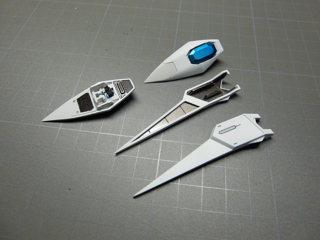 トンガリを増やしたい!という事で、前後のスカートは、プラ板で延長して尖らせました。サイドスカートは、ストライクフリーダムの腕のパーツにプラ板+パテ盛りで尖らせました。あと、Vサイレン ネプチューンのような小さい盾も欲しかったので、OOライザーのパーツを流用して、切って貼ってトンガリ盾つけました。