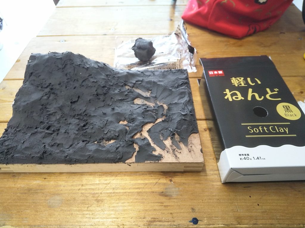 ダイソーの軽量粘土で地形を作る。非常に軽く、乾燥してもやや弾力がある。後でラッカー塗装するので発泡スチロールは完全に覆っておく。なお、粘土が柔らかいうちに歯ブラシ等で表面を叩いておくと砂・土っぽさが出てリアル、というのを後で知ったww