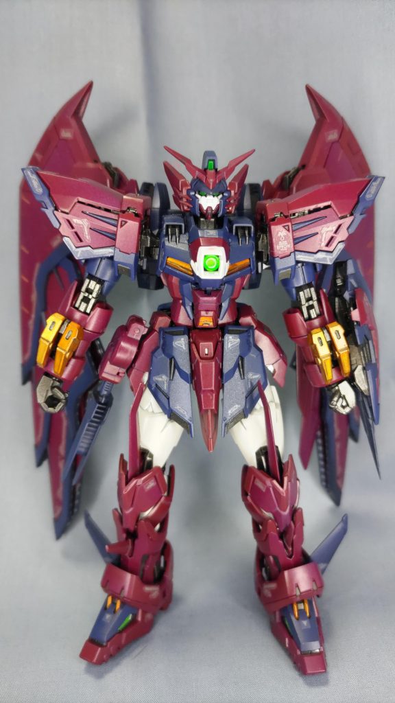 前面から。 他に投稿されている方々のように大胆な色変更も考えたのですが、いつか発売されるであろうRGのウイングゼロ(TV版)と組み合わせる事を考えて、取説のカラーレシピを参考にするいつものパターンに落ち着きました。 わずかな抵抗として、フレーム他黒系パーツはガンメタの光沢仕上げ、黄パーツはキャンディもどきな仕上げにしてあります。また、銀シールを貼り付けるようになっているところはクロームシルバーにて塗ってある他、ウイングや肩等ほぼ目立たないようなところもアクセントとして塗ってあります。