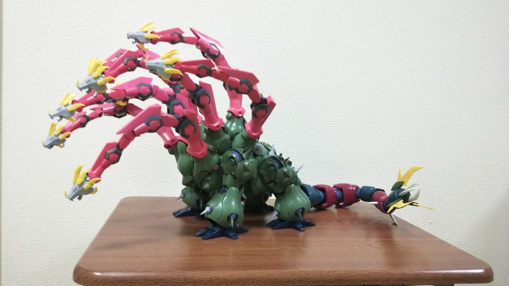 足や首の位置を調整しながら、さらに全体のバランスを整えます。尻尾の先はズゴッククローにジーエンアルトロンの羽をつけて禍々しさを表現。ちなみに体と尻尾の付け根には、自重を支えるための重りが仕込んであります。重りがないと首の重さで前にへたってしまいます。それと今回のヤマタノオロチの作成にあたり、キリンやゾウ、恐竜などの体のつくりを観察し、その形態をミキシングに活かすことで、自然体なフォルムとなるように心がけました。