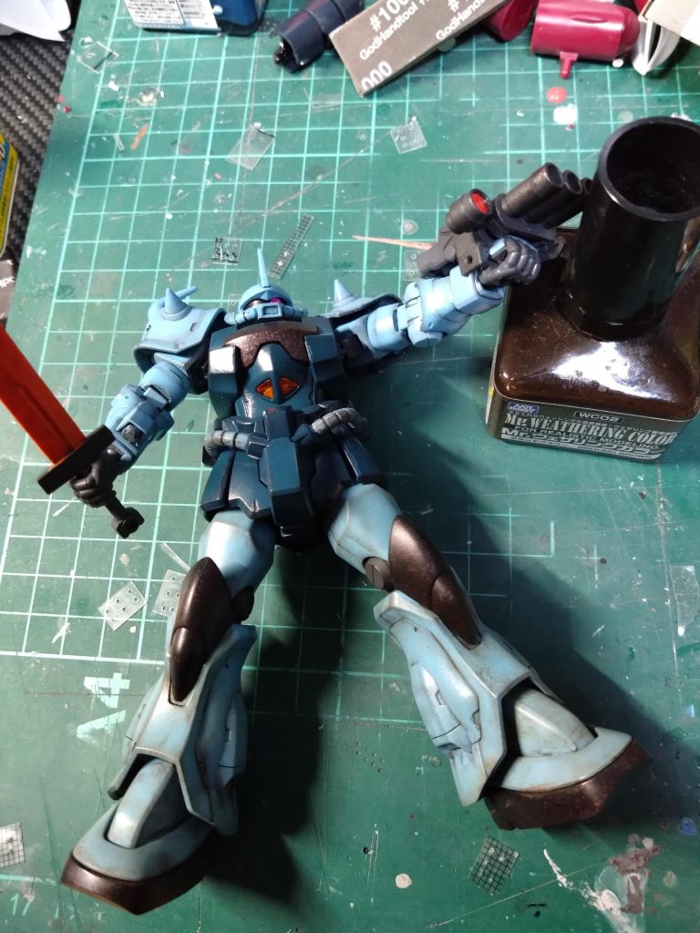 Mrウェザリングカラーのグランドブラウンを全体的に塗って拭き取りしました。写真はまだ脚の部分だけです。過去作品ですが何故か胸や膝、足等の黒いパーツにメタリックレッドを少し吹いてあります。何故こんなことをしたのか？黒く塗り直しました。少しですがこの後ディティール追加してます。