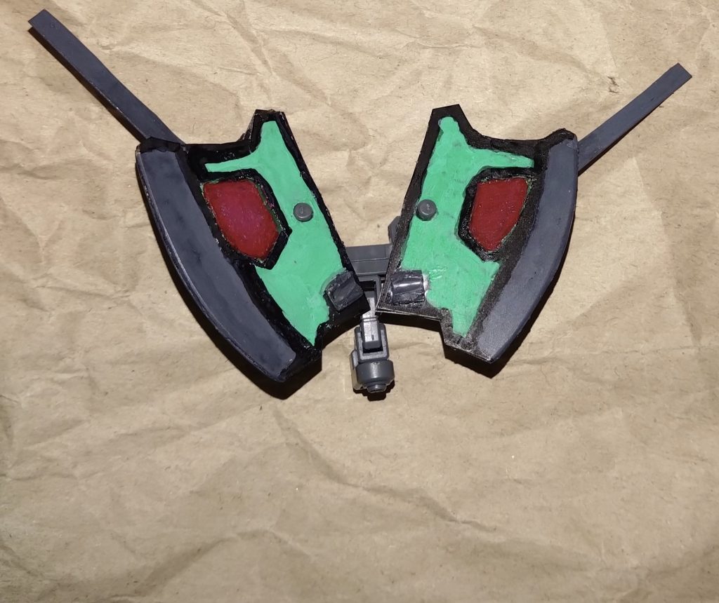 斧に弓、それ以外にもう一つの使い道があります。それは盾、シールドです。使わない時は常時、胸部分に装着されており、普段から胸を守るモノになっている。このシールドの防御力は一番高い。ビームも防げるのですが、こちらは実弾や物理攻撃によって受けた振動・衝撃を吸収し、自らのエネルギーに変換することができます。ビームを吸収してエネルギーに変換する扇子武器『リベロファン』とは正反対とも言えるモノ。ロビンスリベロはエネルギー問題が無い形態だが、他の形態に必要なエネルギーの回復を目的とした形態とも言える。