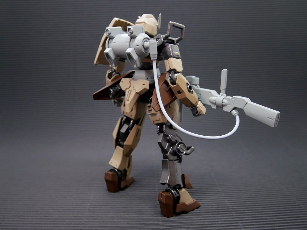 大型のスナイパーライフルを保持するための補助アームユニットを股間に持つほか、狙撃ポイントで機体を固定するための懸架フックを各所に備える。右膝には低重心(膝立ち)での狙撃姿勢を保つため膝を延長する大型フックが設置されている。