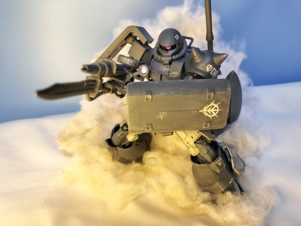 銃剣付きザクマシンガンを撃ちながら、手持ち盾を使用し先陣を切るオルテガ機。マシンガン使用時は巨大ヒートホークを背中に懸架します。