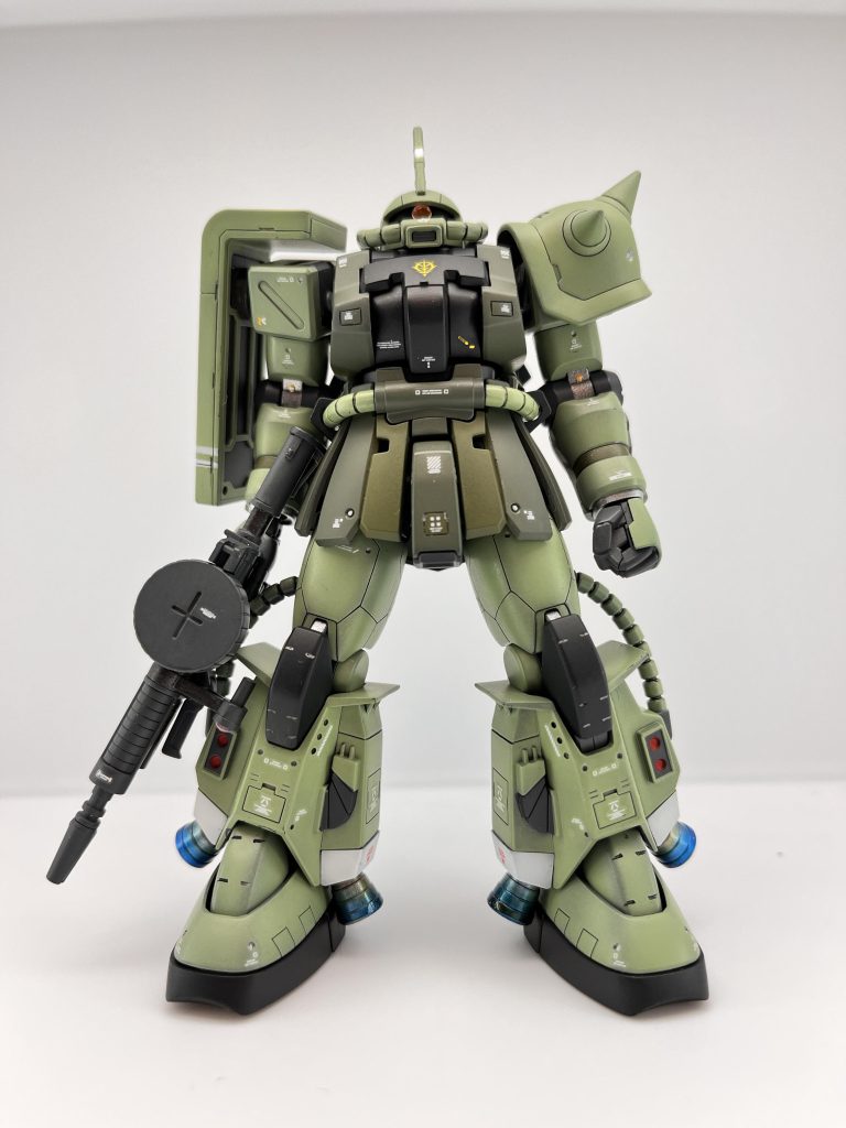 前方より。統合整備計画が発令され、それに基づいた新機体の作製と、従来機の改修、設計の変更が並行して実施された。MS-06R1、06R1Aの型式で知られる高機動型ザク前期型にもこの手が及んだ。本機の新規生産自体は終了していたが、補修品や消耗品の生産が続けられていた事や、損耗するであろう脚部とバックパックがかなりの数ストックされていたことで改修リストに名を連ねたのである。