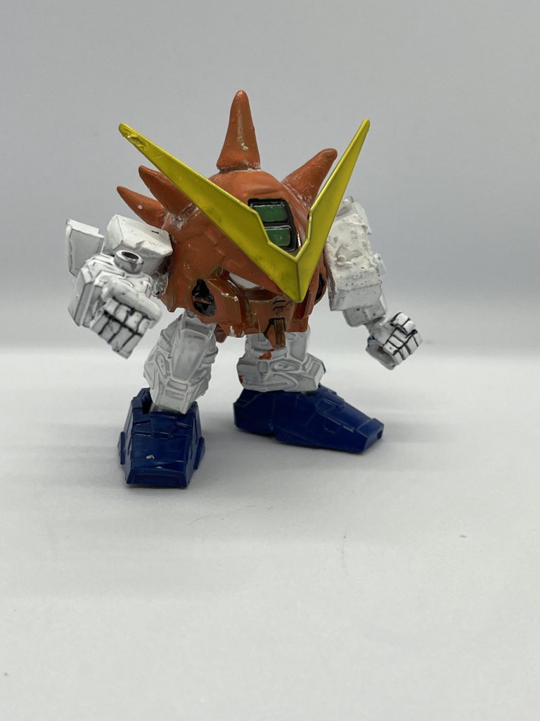 使用したキットはEXSDのガンダムアストレイレッドフレームを改造して、中の人繋がりで首領パッチに改造しましたw改造点は頭部の下の後頭部と腰部の一部を切り取ってパテと接着剤で成型して顔兼身体を作成し、両肩を一回り切り取り肉抜きをパテで埋めました。使用した塗料はアクリジョンのオレンジ、ホワイト、イエロー、ブルー、グリーンで塗り、半ツヤのトップコートをかけました。