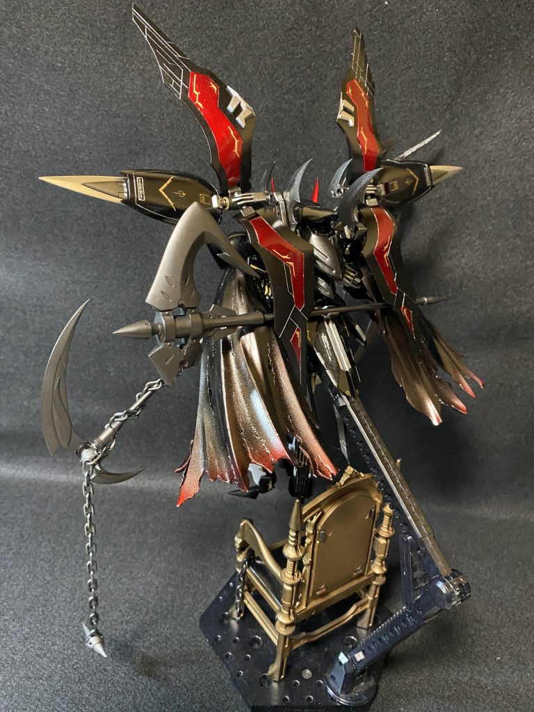 ✨背面斜めから１枚✨グリムゲルデの腰部背面アーマーをミキシングし、バトルアンカーを背面に保持出来るように改造🫡 マントは写真では分かりにくいですが、黒下地にほんのりクリアレッドを重ねて破れた先端や裾先の方にかけてグラデーション塗装🎨 最後にマントヒダの山部めがけてふんわりシルバー塗装正面から見た時、上空から舞い降りてきた感じに見えるようアクションベースの支柱を玉座で隠してます ⁾⁾|д･) ｿｫｰｯ