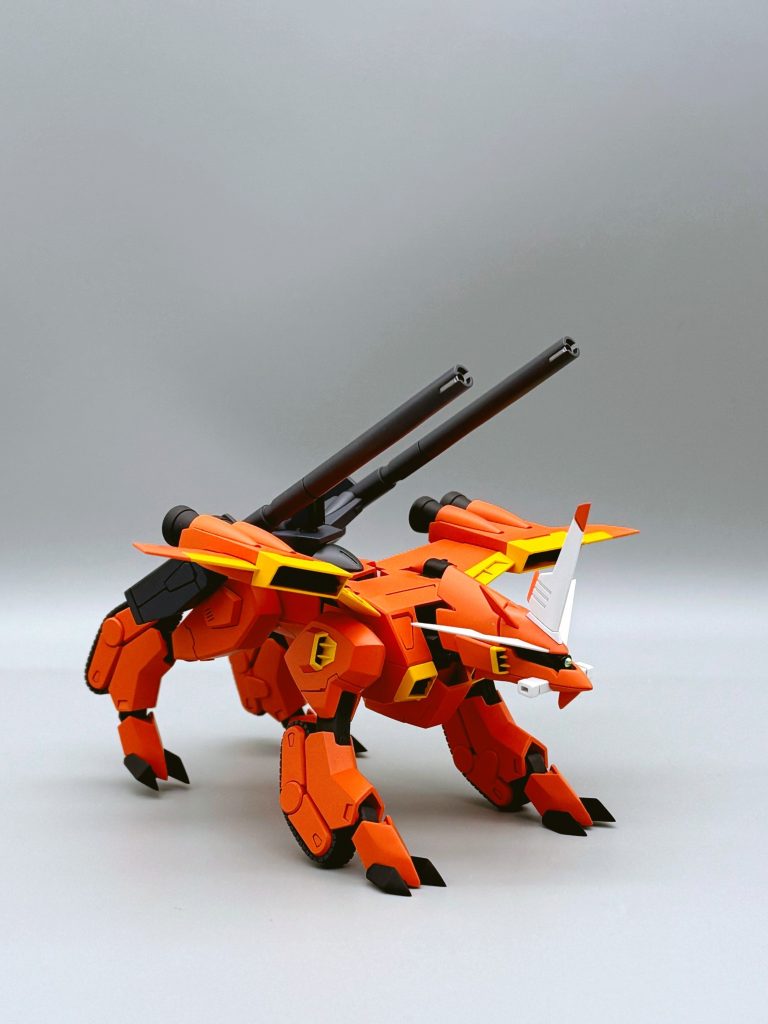 外装色はピンクサフをベースにマンダリンオレンジにマゼンタと少しのグレーを足して調色、少し濃い目にしました。なんか写真ではいろいろつぶれてますが、関節はメカサフスーパーヘビィ、爪は青に黒を足しながら黒寄りにして、目は黒、目の部分は前面の一部を縦に切ってハイキューパーツの2mmをはめてます。武器とスラスターはガイアノーツのダークブルーイッシュパープ。スラスター内部は赤にしました。ちなみに武器の先端は銀っぽかったので銀を入れています。(箱絵を見て気が付き、見本をよく見ると塗ってある。初めて知った!!)スラスター・関節・爪は艶消しにして、武器・外装などは半ツヤで、目・角系は光沢にしてます。