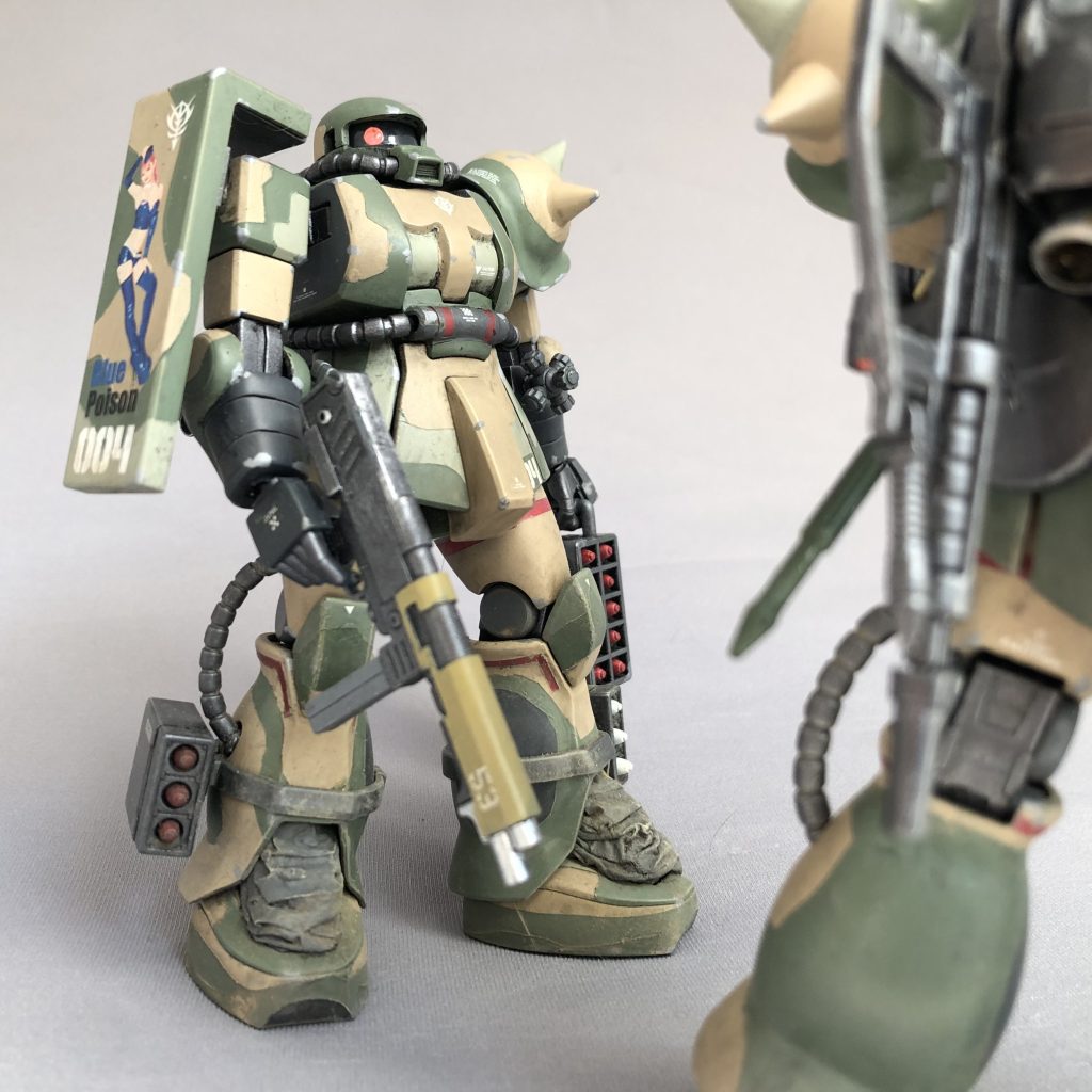 隊長機と同じく元ネタは、ファーストガンプラ世代の聖典HJ誌別冊「HOW to Build GUNDAM」掲載の川口名人の作例です。一般機は装備が特徴的です。川口名人の作品では一般機はオリジナルのアサルトライフルを装備しておりました。当時としてはザク用の銃器と言えばザクマシンガンとザクバズーカしかなく、オリジナル銃器も有だったのでしょうが、今やザクの装備できる銃器は選り取り見取りですから、既存の銃器からMMP-80をチョイス。銃身はカーキに塗装してあります。右腰にはMMP-80用マガジンもぶら下げています。