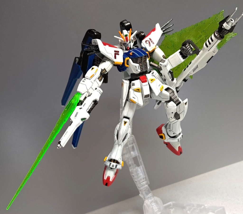 各基本兵装を手にして、パケ絵に近いポーズ! 両腕がビームシールド付きとなっております。左右の前腕部の先端を開口し、HGのダブルエックスのハイパービームソードの刃を装着できるようにしました。ビームライフルは2丁拳銃になることを見越して、各部を切り飛ばし小型化してます。銃口の代わりにICピンソケットを埋め込みました。またフォアグリップがあった箇所と機体のサイドスカート裏面に磁石を仕込んでパテで埋め、腰にマウントできるようにしてます。ビームランチャーのグリップは一度切断して上下逆にして接着しました。腕下に沿わせて持ちたかったので。