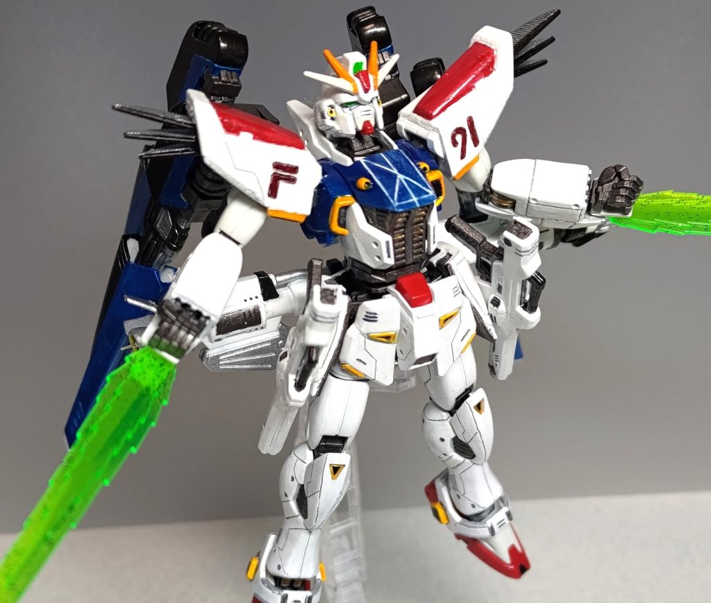 胸部中央の青いパーツを差し換えて、イ デ 発 動。バグごときイデバリアで弾き飛ばしてやろうというものです!w腕の先から光剣が伸びている様子がイデオンソードに見えて、コクピットハッチがイデゲージっぽいなと思ってしまって、ニコイチでパーツ2個あるんだからやっちゃえ!ってことで、最大最強のジムの力を小型ガンダムに宿しました。胸部の白い墨入れはタミヤアクリルのホワイトです。コスモ「メガマシンキャノンもだ!」トビア少年「同じ富野監督作品だからって、無責任なもんをーっ!!」