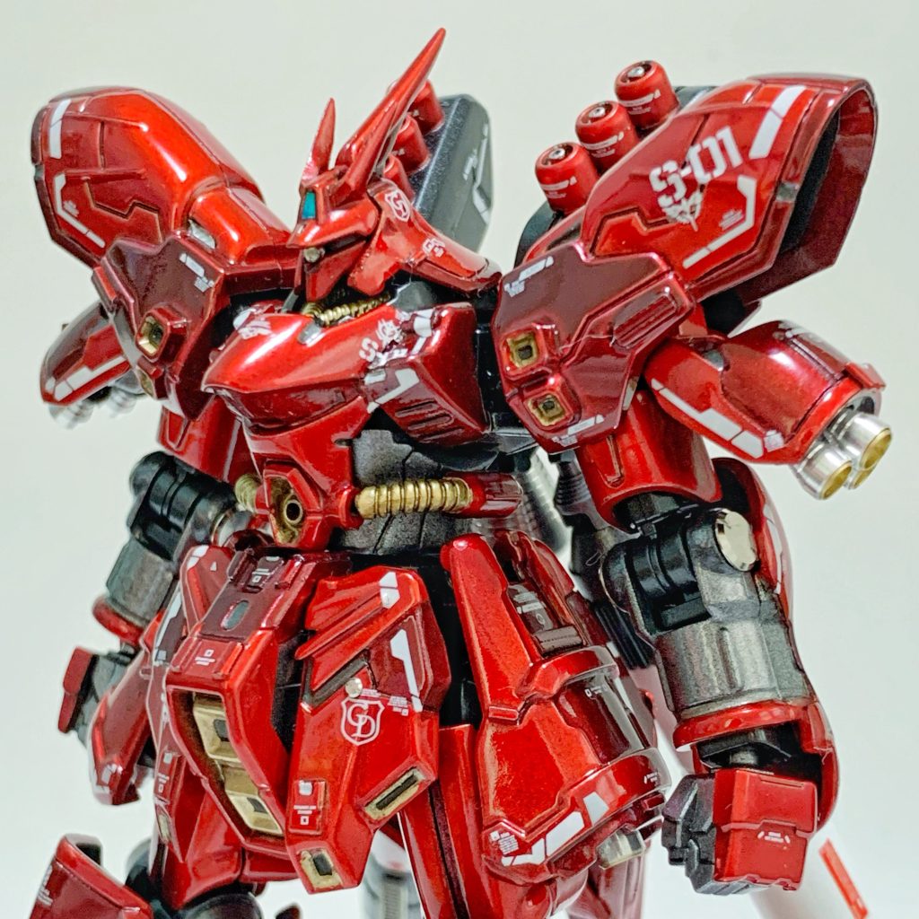 今回、フレームの延長加工などは行わず、アーマーパーツの改修に重きを置いて仕上げました。自身初となるスジボリ追加は、解体匠機やRG・MGのディテールを参考に追加。肩アーマーやフロントスカート、膝アーマーなど、スジボリに合わせてキャンディ塗装の下地(ゴールドとライトガンメタル)を変えることで別パーツ感を強調しています。