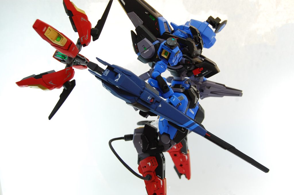 横から見たシルエットは、くの字に・弓なりに見えるようにしました。足は30MMのエスポジットのもので姿勢制御用の脚ですが、逆関節っぽい取り付けになって新鮮な感じになったと思います。他バックパック上部はギャプランのもの、左もものライフルはエアリアル、ロッドライフルに付いてるのはリゼルのパーツ、手はシュバルゼッテ、胸はジャンクの足先などを組み合わせたものです。 マスクは少しうつむいたときに胴や首回りと同化して見えるようなものにしました。30MMシエルノヴァオプションパーツのマスクの下半分にアスタロトの額をつけたものでネオジム接続になっており、マスクの摩擦がかかる部分をちょうどアンテナなどのクリアパーツにくるようにして着脱時の塗装ハゲ対策をしました。マスクのクリアランス調整だけは毎回うまくいってる気がします。モノアイは緑のクリアランナーにレジンを垂らし、ネオジム磁石にレジンで直付けして光が反射するように。