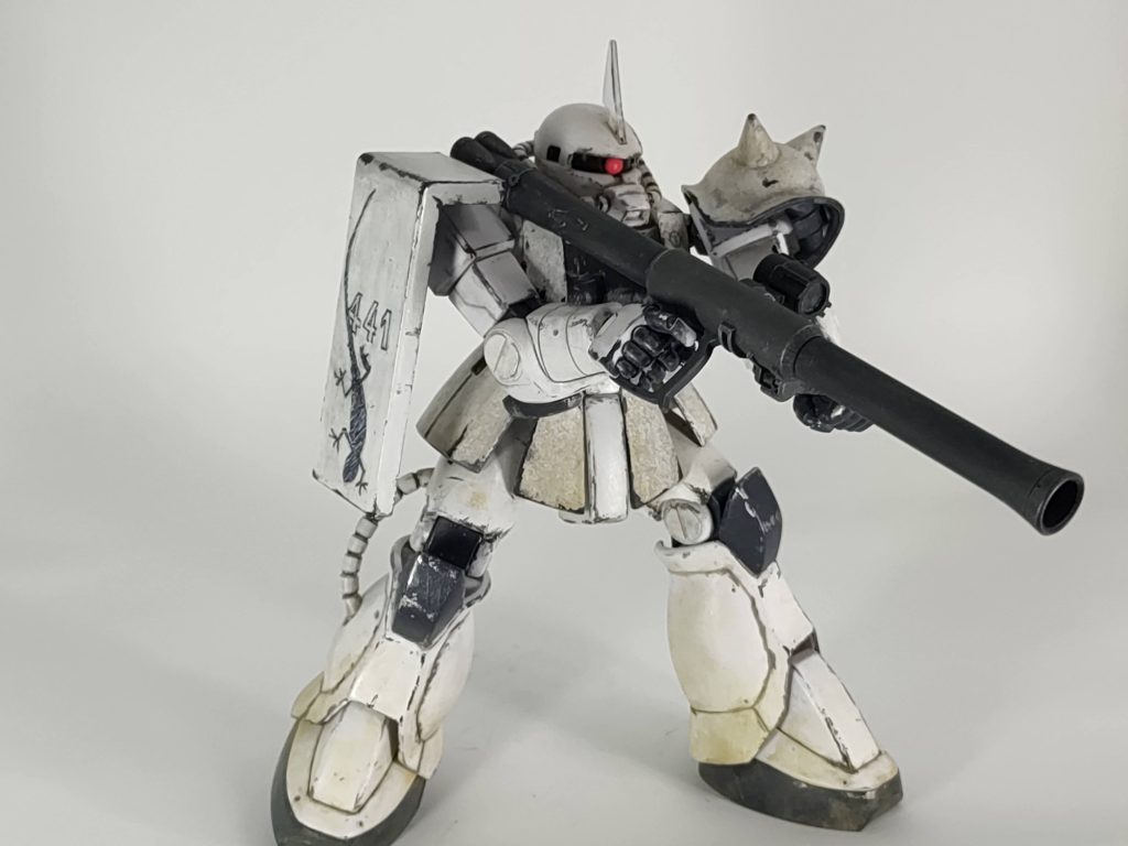 あまり動かないのでポージングが辛いです。一番の問題、トカゲマークはガンダムマーカーの墨入れの細いペンで手書きしました。シールドのトカゲはなんとかなった(と思う)のですが、441の数字の方がよれよれで全然ダメでした。更におでこは小さすぎてこれ以上細く書けないので、これも全然ダメ...雰囲気だけで勘弁してください。(どの写真にも頭のマークは映っていないからよしとしよう)お腰につけるはずの卒業証書入れの筒x2も再現できずギブしました。胸のジオンマークはこのためにガンダムデカールを買ってきたのですが、黒いマークがなくてグレーのマークで代用しているためコントラストが低くよくわからない。