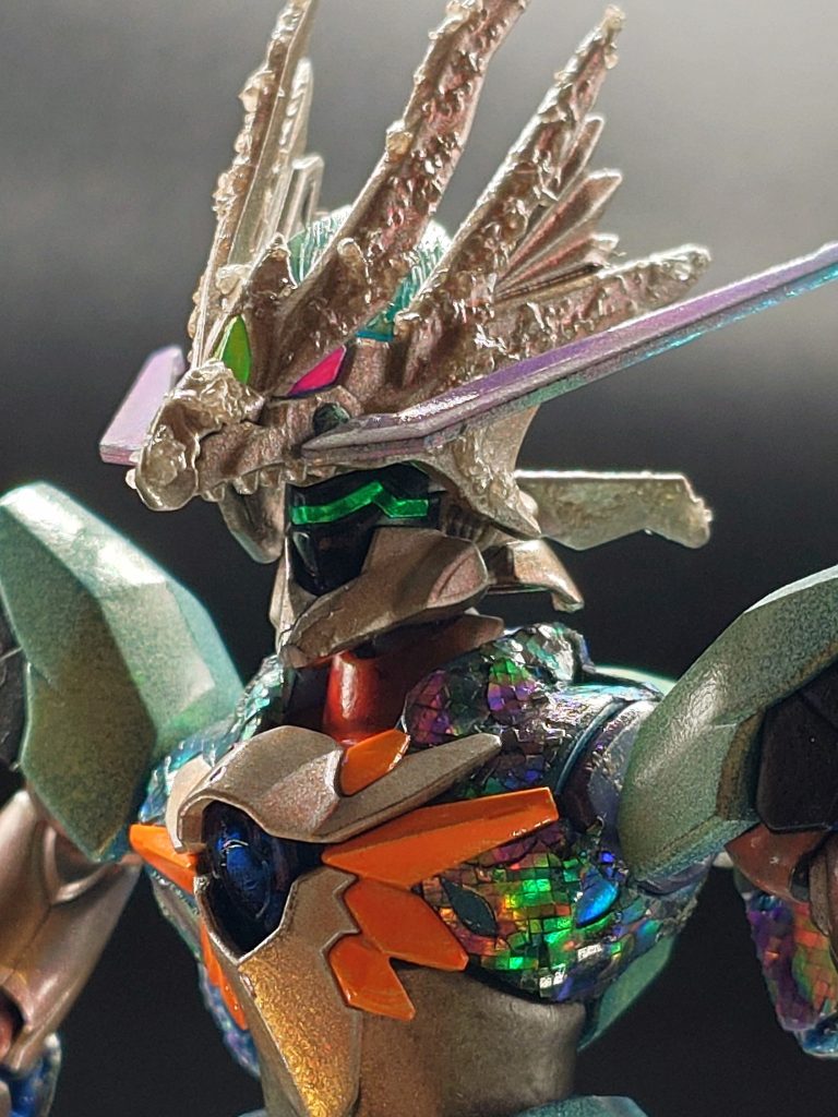 ベースキットのギラーガからして何処となく爬虫類感漂うフォルムながら、やはりお顔にはツノとヒゲは欠かせない!ということで辿り着いたのが、SDガンダムシリーズの「シャイングラスパードラゴン」とのミキシングでした。ギラーガの頭に合うようにちょこちょこルーターで削り瞬着でポン着けしただけで上手い具合に納まったかなと。その他、より生物の肌感を出すために、リキテックスのレジンサンドを盛っています。