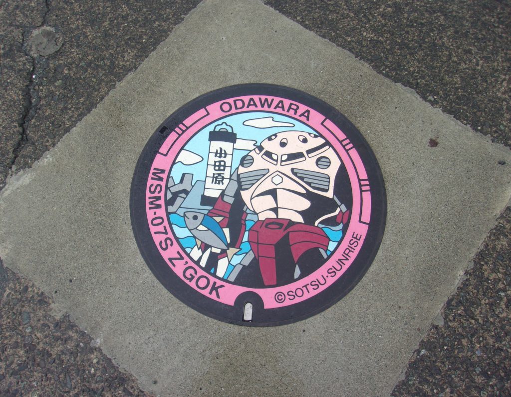 マンホール全体。ズゴックの背後にあるのは小田原ちょうちん灯台です。