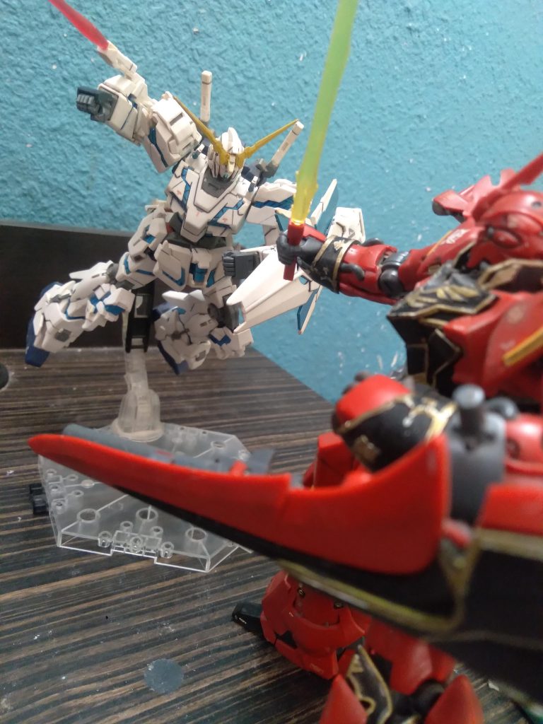 The Unicorn Gundam charges at the red Sinanju, it's beam tonfa deployed