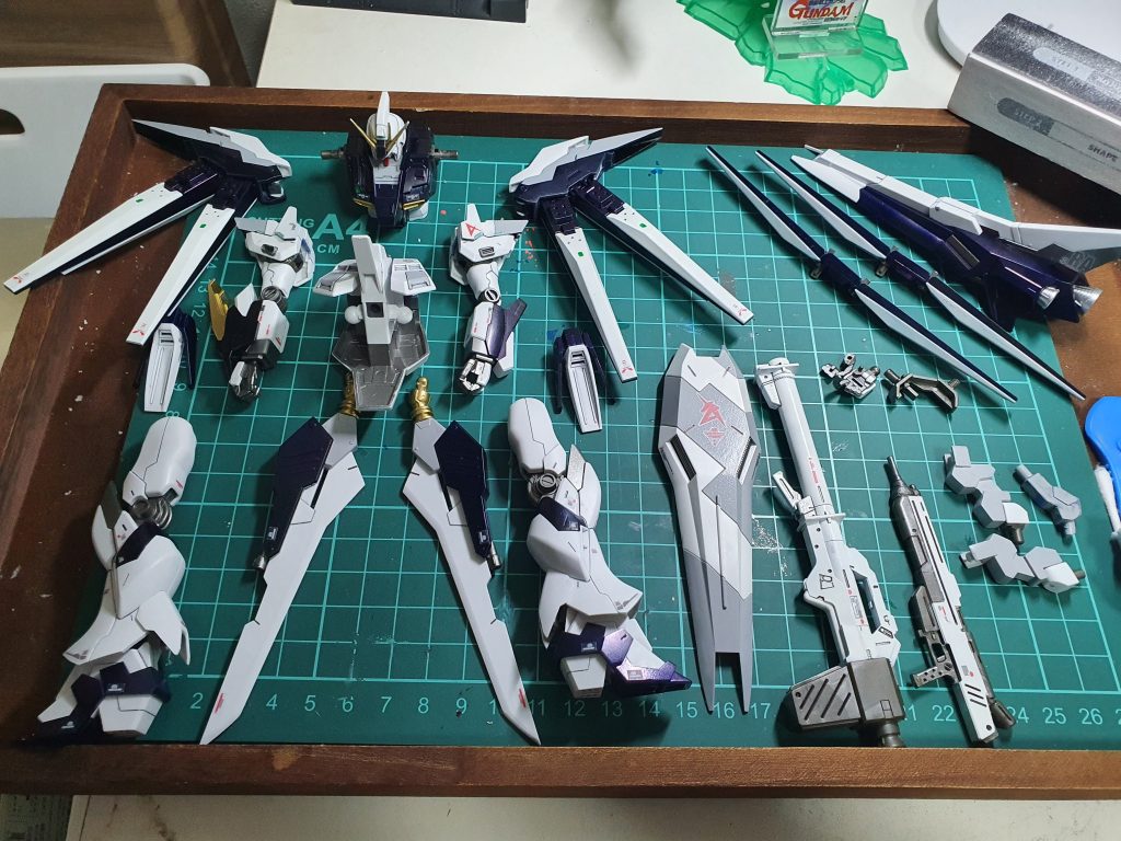 組み立て前のパーツです。(後になって白鳥の頭のパーツを載せ忘れたことに気づきました…)カラーレシピは下記の通り。(ガンダムマーカーエアブラシシステム中心に、一部は缶スプレーです)当初のブルー部分:Mr.カラーメタルブラック→マッキー青(擬似プリズムブルーブラックを目指しましたが、なってますかね?)ホワイト:モデラーマーカーホワイト、一部Mr.サーフェイサー1200グレーライトグレー:Mr.サーフェイサー1200グレーグレー:モデラーマーカーメタグレーレッド:ガンダムマーカーレッド当初のイエロー部分:ガンダムマーカーゴールドファンネル各パーツ:モデラーマーカーホワイト、Mr.カラーメタルブラック等ツインアイ:ガンダムマーカー蛍光グリーン最後に全体をつや消し→光沢(疑似半光沢)デカール:RG νガンダムのリアリスティックデカールその他ディティールアップ・当初Hi-νガンダムヴレイブのテールブースターだったパーツを、白鳥の頭に見えるように一部改造・カラーリング・ファンネル格納部分の上開口部→プラ板とプラシール(擬似フィン)・緑シール部分:緑ラピテープまたはマッキー緑の上にUVレジン・頭部アンテナ鋭角化 等