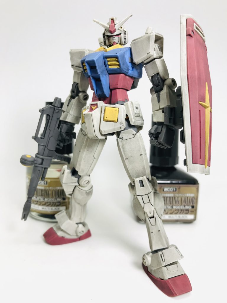 次にウォッシングですMr.ウェザリングカラーマルチブラックを全体に筆でベタ塗りしますこのウォッシングは墨入れも兼ねているので、墨入れする時間と手間を短縮できるのも良いところウェザリングカラーはエナメル系なので、関節など負荷がかかる部分に塗りすぎるとパーツが割れる可能性があります肉眼では確認できない微細な傷に塗料が入り込みプラを侵食し脆くするそうですとくにABS製のパーツは危険慣れてない方は外装パーツだけにした方が良いかも…私は基本薄め液は使用しません、溶剤を増やすとパーツが割れる可能性が高くなる為です頭部、胴体、腰回り、両腕、両脚、バックパックの8つに分解してベタ塗りします(武装などある場合はそれも)あ、Mr.ウェザリングカラーマルチブラック…瓶が新しくなりましたね、四角から丸くなりました(笑)