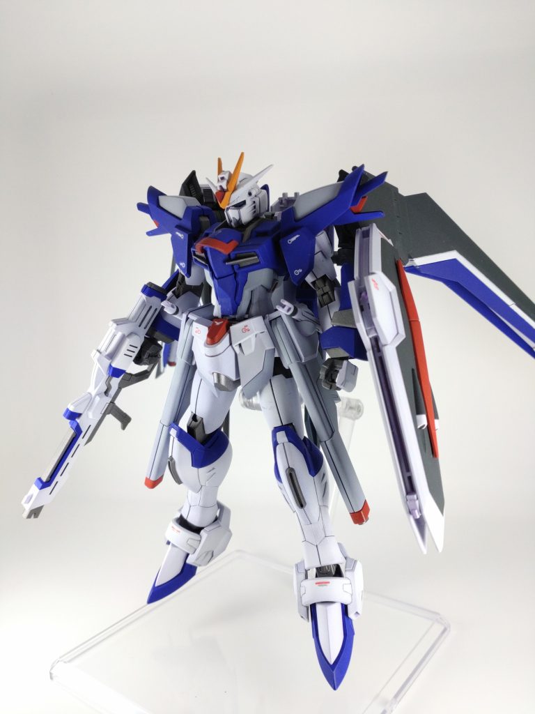 塗料はガイア　フラットホワイトガイア　スターブライトアイアンガイア　ブライトレッドガイア　ミッドナイトブルーナスカ　マンダリンオレンジガイア　フラットホワイトにミッドナイトブルーを混ぜたグレーフィニッシャーズ　ブルーパープルガイア　蛍光クリアガイア　蛍光レッド＋クリアーレッドカメラアイの縁取り、バルカン、ライフルのスコープ部分等のワンポイントにはタミヤのエナメル塗料を筆塗り。どうにか他のモデラーさんとの差別化をしたくて下地はガイアのサーフェイサーEVOパープルを吹いてみました。しつこくならないレベルで微妙にグラデーションをかけましたが、写真じゃあんまわからん。後はテキトーに余ったデカールを貼り、エナメルダークグレーでスミ入れ後、全体をつや消しで仕上げました。最近スターブライトアイアンにつや消しを吹いて少しマットな感じにするのにハマってます。統一感が出る。気がする。