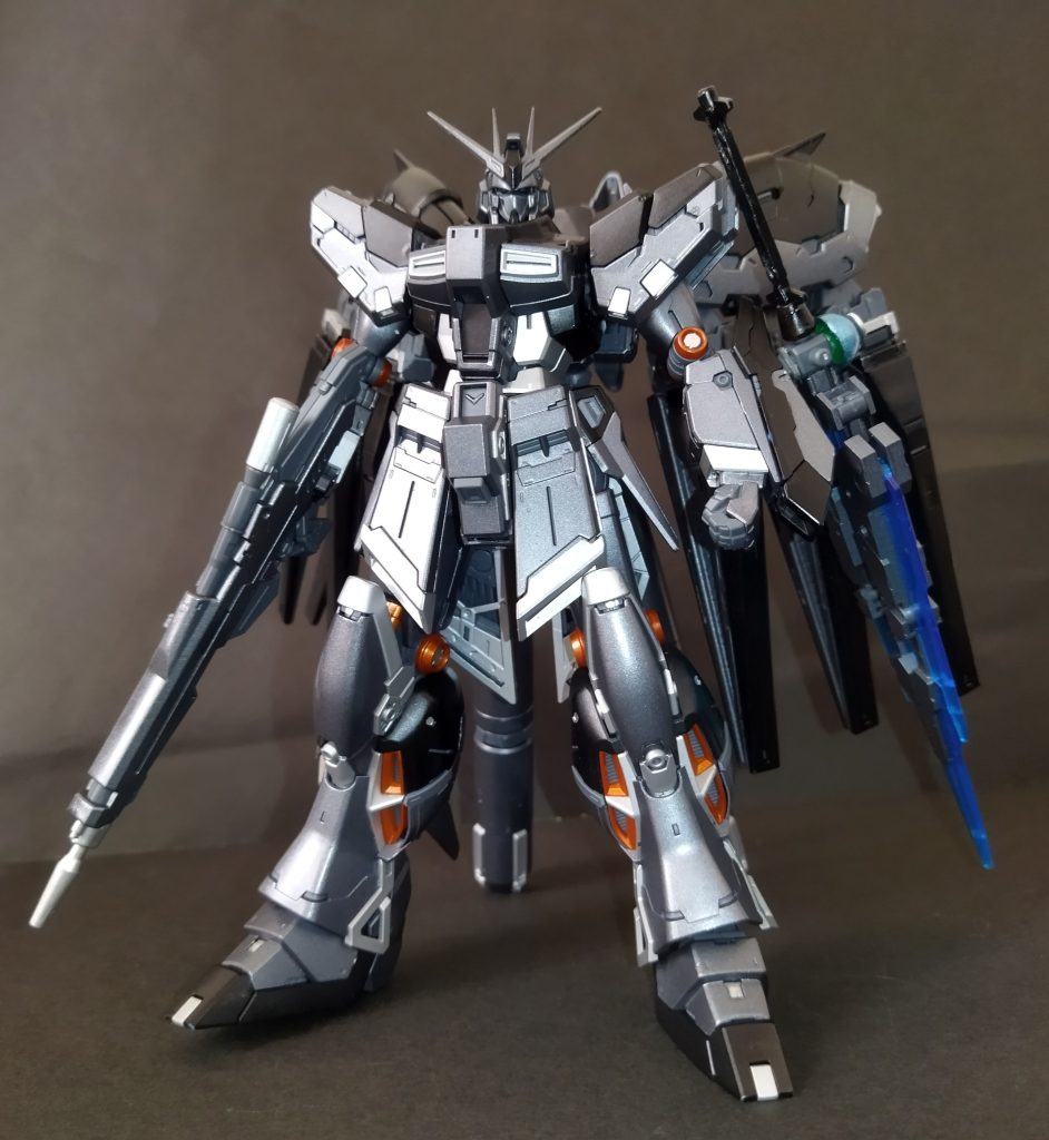 第二次ネオ・ジオン紛争の最中、次世代MS開発研究の一環でRX-93vガンダムと並行して作られた機体。vガンダムと一部フレームを共用しているが、それ以外は外観及び設計も大幅に異なっている。外観的特徴の一つでもあるガンメタルの装甲色が目を引くが、実はMSN-00100百式と同じ耐ビームコーティングによるものである。一説によると経年による研究及び改良の結果、百式のものよりもビーム耐性が約30%も向上しているという。バックパックにはνガンダムと同様フィン・ファンネルを搭載しているが、本来の用途と機能をオミットした代わりに、そのビーム発生の動作原理を応用し高機動推進装置に転換。追加武装としてサイコフレームの素材を刃状に形成したバリアブルサイコブレードを装備している。あまりにも高コストであることと、開発途中で戦争が一応の終結を見たためこの機体が陽の目を見ることはなかった。しかしそれはあくまで表向きの話で、水面下では何者かの手に行き渡り密かに開発が進められ、ノワール=黒き機体色の如く、宇宙世紀の歴史の陰で人知れず暗躍しているらしい。