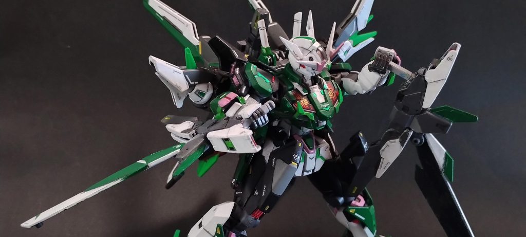 また、ダブルオースカイメビウスのアームドウィングバインダーは基本「剣&ビーム砲」でしたが、ガンダム・コーディリアのアームドブレードバインダーは、これに加えて「トンファー」としても利用可能です。通常の手持ちビーム砲とした際に利用可能なのは片側(スカイメビウスでいうところのバラエーナ砲)の砲口だけでしたが、トンファーモードの場合はもう片方(スカイメビウスでいうところのクスィフィアス砲)の砲口も、拡散ビーム砲として利用可能です。これによって、「手持ち武装で広範囲にビームを乱射して相手陣形を崩し、隙を作ってトンファーブレードで一撃を入れる」といった柔軟な攻撃が可能となっています。……つまり、トンファービームが撃てます。(去年のFC岐阜の「相手守備にプレッシャーをかける、前線からの執拗なハイプレス」を武装で表現した…つもりです)画像はまさにトンファービームを撃とうとしている場面です。ギリギリ、右手に持つ複合兵装の赤い砲口が見えるかと思います。