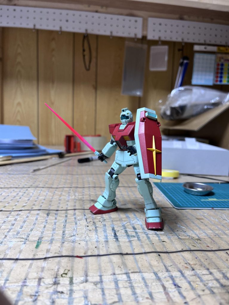 手とバルカンを塗ったついでに、少しだけ汚しました。絶対に汚さないと心に決めてましたが、やっぱり汚しました。ついでにサーベルも塗ったのですが、僕は設備が乏しいので、筆で白を塗って、蛍光ピンクを重ねて、部分的に紙ヤスリで削って、蛍光ピンクで重ねてグラデーションっぽくしました。この写真の距離で見たら、なかなかの出来ではないでしょうか。よく見たら、サーベルの柄の部分塗り忘れてますね。