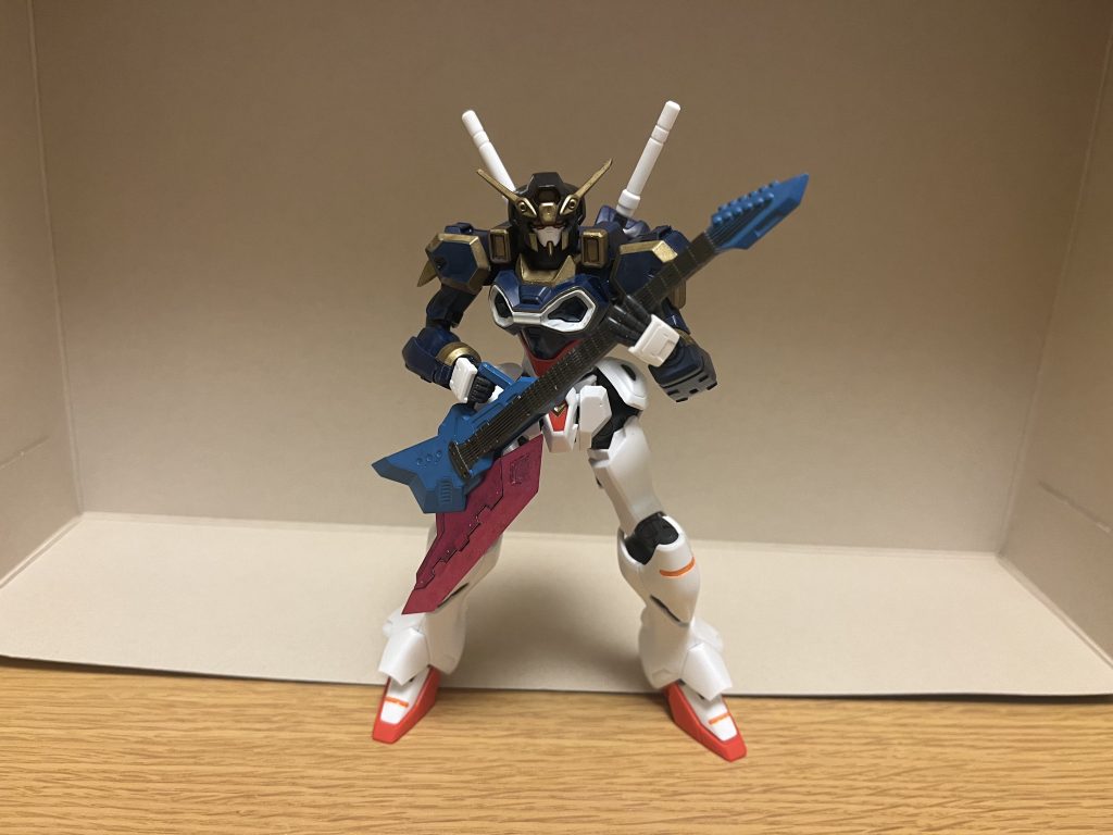 ギターアックス幻想具現化によって創造される本機専用の新規武装であり、ギターのように持てばギターモード、弦の部分を握ればアックスモードとして運用する為、身も蓋もない言い方をすれば「物理的に殴れるギター」である。ピック部分を掻き鳴らすことで実際に演奏可能な他、本武装から発した音色を火炎・電気・氷の3種類のエレメントに変換し、攻撃に転用できる。刃部分は、様々なエレメントに変換された音を刃全体に纏わせ、楽曲や攻撃を超刺激的に表現し、ダメージを与える事が可能。ちなみに刃部分さえ当てられればダメージになる為、逆手持ちの要領でギターモードで振り回しても攻撃できる。ただし、バフによる支援強化を主軸としている仕様上、刃自体は斬れ味と破壊力に特化しておらず、PS装甲に有効打を与えるのは難しい(大きさと質量の高さから、それらの機体にも衝撃によって、パイロットや電装品にダメージは与えられる)。