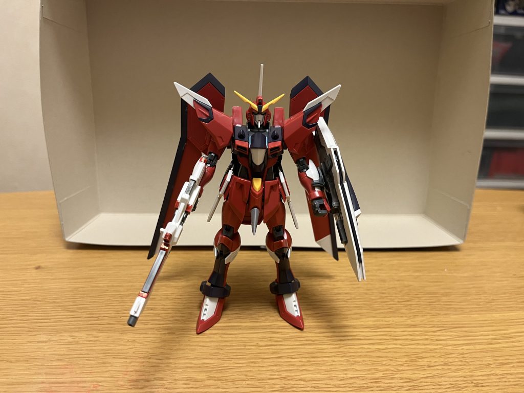 機体名:イモータルジャスティスガンダム全高:18.50m重量:71.62tZGMF-X19A インフィニットジャスティスガンダムの運用データをもとに開発された世界平和監視機構コンパスの専用機。機体本体の設計はオーブ連合首長国(モルゲンレーテ社)、武装の開発・製造はプラントの二大兵器メーカー(及びザフトの統合設計局)が担当するなど、国家・体制の枠を超えた最新技術が集結している。兄弟機のライジングフリーダムガンダムと共通のフレームを採用しており、運用方法に応じた機体や武装のバリエーションを生み出せるマルチロール的な特性を持つ他、大気圏内と宇宙を往還するコンパスの活動範囲に対応する為、オーブ軍のムラサメの可変技術を導入した飛行型のMA形態への変形機構を採用している。パイロットは、シン・アスカ(IF版)。経緯についてキラとの共闘までの流れそれまでは「リベンジャーズの王」としてオーブへの復讐の為に戦っていたシン・アスカだったが、その戦いの最中にオーブの悪の科学者の手によって、大事な腹心は利用された挙句、殺されてしまう。科学者はそれだけに飽き足らず、自分たちを捨て駒にしてまで、オーブどころか国全体で戦争を起こし、大虐殺を愉しもうとするなど、常軌を逸した彼の悪逆は収まる事を知らなかった。大切な友を殺されたシンは、今まで断固として行わなかった「オーブとの一時共闘」を選ぶ覚悟を決め、さらには自らが認めた好敵手とも雌雄を決する約束をし、ルナマリア・ホークを引き連れて、キラたちと一時共闘した。その戦いの果てに、またしても仲間を失い、シン自らも致命傷を負ってしまうが、それでも科学者を何とか倒した後、好敵手との最後となる決闘を行い、命を燃やし尽くすまで戦いを楽しむ。だが、シンの身体は遂に限界を迎え、好敵手とキラ、カガリとアスランに対して「オーブの巨悪に抗い、新たなオーブの支配者になろうとした自分たちリベンジャーズの存在を忘れないで欲しい」と最後に懇願し、好敵手とキラだけでなく、彼への行いに悔いていたカガリとアスランもまた頷き、それを聞いたシンは涙ながら満足な笑顔を浮かべて、その場に崩れ落ち、その生涯を終えた.................はずだったが、死んでいたと思われた仲間の最期の償いによって、シンは再び命を吹き返す。こうして奇跡的に蘇ったシンは、オーブにある慰霊碑の前に、ルナマリアと共に訪れ、キラ・カガリ・アスランと再会。そこでキラから「身内の一人としてカガリとアスランを止められなかったこと」「オーブの人間として、本来救うべき国民であるシンを裏切り続けたこと」「シンの大切な仲間や友達を死なせてしまったこと」などを、キラなりに自問自答した末の結論として、シンに土下座してまで謝罪する。それに続けて、カガリとアスランも「自分の過ちから逃げないこと」の覚悟を示す為に頭を下げて謝罪した。その姿は「甘さや傲慢さを捨てて、自らの非を認めて、他者に感謝と敬意を示せるようになった」シン自身の姿そのものであり、これには当のシンも驚きを隠せずにいた。そして、キラはシンに共に戦う事を持ちかけ、カガリから「オーブとして償う姿を見ていて欲しい」と言われ、シンは「次に裏切れば容赦しない」としつつも、彼らなりの誠意を受け取り、和解する。その数日後、カガリ・ユラ・アスハは、悪の科学者を含めた上層部たちが起こした悪事を全て公表。シン・アスカのみならず、オーブ被災国民に対しても、誠意を込めた謝罪と再発防止の徹底を約束したのだった。それに伴って、シンも「リベンジャーズ」の活動を一時休止を宣言(解散ではなく一時休止にしたのも、オーブの償う意思を監視する為である)。オーブに牙を向けようとした復讐者は、一旦はその矛先を収め、オーブの誠意を見届ける事を決めたのだった。それから数年後、キラ・ヤマトの目指す未来に共感して、ルナマリアと共に世界平和監視機構コンパスへと入隊し、キラの部下となり、彼から本機を託されるに至った。コンパス入隊後の活躍についてヤマト隊への配属後、シン自身のリベンジャーズを率いてきたカリスマ性や圧倒的な戦闘能力も相まって、パイロット能力の高さ故に「1人で抱え込みがち」であるはずのキラ・ヤマトですら「自分より遥かに強い」と太鼓判まで押すほど。実際にヤマト隊でも、キラ直々に副隊長や重要任務を度々任されたり、参謀としても活躍している。さらには「フリーダムとジャスティスの生みの親」としてプライドの高いはずのミレニアム技術全般責任者のアルバート・ハインラインにも、かなりの信頼を寄せられており、キラやラクス同様に多少ながら敬意を払われている。ただ、同じ隊員のアグネス・ギーベンラートからは、原作同様の「山猿」などと呼ばれるのみならず「オーブに見捨てられた逆恨みで、ザフト軍を抜け出した裏切り者」とまで言っており、IF版のシンの過去も含めて、彼を快く思われておらず、今のシンの実力も認めていないばかりか、未だに見下そうとすらしているが、キラや他の隊員からは何度も嗜められ、当のシンからも相手にされず、現在ではアグネスがマウントを取ろうとして、シンの実力差によって失敗するのがお約束のパターンになっている。現在の性格についてメンタルは、原作(劇場版)と同様に全回復している。リベンジャーズの王として活動していた頃の落ち着いた性格は健在で、その冷静さと判断力は、キラとラクスにも一目置かれており、彼らから相談を持ち掛けられる事も多く、その姿は「コンパスの陰の実力者」と周りから噂されているほど。その背景もあってか、基本的にはリベンジャーズ時代の性格を表に出しており、普段は本来の明るさを出さずにいるが、シンとしても「キラに頼りにされる」のは凄く嬉しいらしく、序盤は「キラに頼りにされない」という悩みを少なからず抱いたり、終盤で「ミレニアムとレクイエムと頼む」とキラ直々に頼まれた際には嬉しそうに返答するなど、以前のような本来の明るさは完全に取り戻してもいる。キラに対しては「さん」付けだが、原作ほどの忠犬ぶりではなく、冷静ながらもある程度はタメ口に近く、対等に近い一歩手前の目線で話すなど、関係は良好。コンパス総裁のラクスとも、お互いに「プラントの歌姫」「リベンジャーズの王」というかつての立場を超えて、敬語を使わず対等に話せる間柄となっており、キラと同じく「上に交わりて諂わず、下に交わりて驕らず」という姿勢を貫いている(流石に公共の場では、お互いに敬語を使っている)。対してシンも、キラやラクスの悩みや本心などを一目で見抜き、自らの経験に基づく助言をしたり、キラの信頼を得ようとしたり、時にはシン自らが話しかけたり、逆にラクスとキラがお互いに話し合える機会を作ろうとするなど、彼らの負担を減らそうとも試みている。一方でキラ自身は、シンに対するオーブでの過去の仕打ち(過去の拷問や人体実験)もあって、内心では強い罪悪感を抱いており、「今更シンに頼るのは虫が良過ぎる」「彼の願いに応えるのが当たり前であっても、自分たちは償いの為にもシンに縋る事は許されない」とまで思い詰めている為、中々上手く行かずにいる。アスランとは、険悪とまでは行かなくなったが、挑発し返す応酬が繰り広げられ、仲の悪い兄弟みたいな関係に落ち着いている(現在もその殆どが、シンがアスランを論破・言い負かすパターンとなっている)。