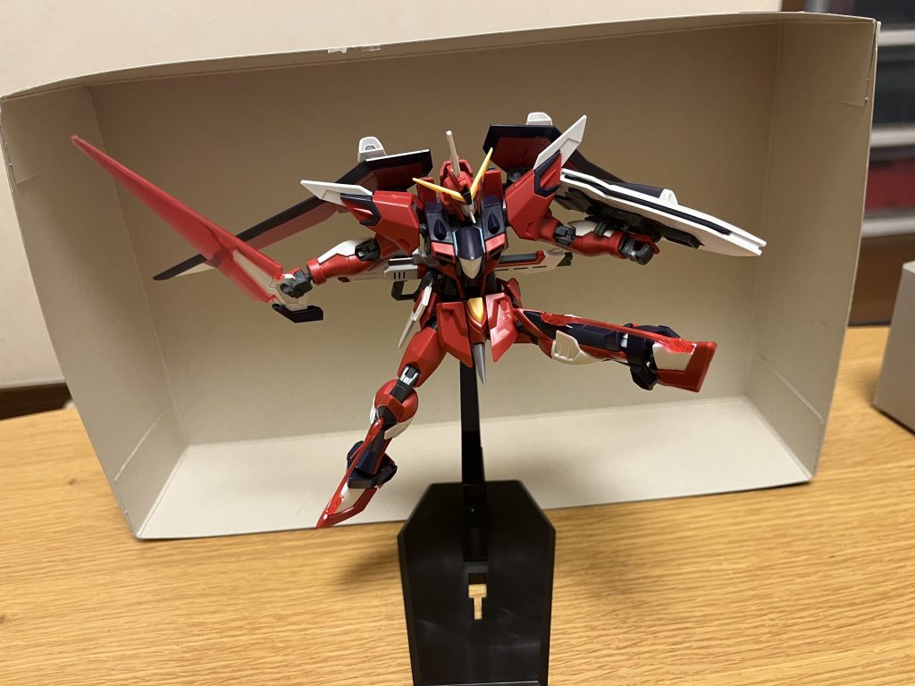 開発経緯について元々「フリーダム」「ジャスティス」の名を関するMSは、クライン派やその流れを汲む公的組織を象徴するフラッグシップであり、本機は「世界平和監視機構コンパスの威信を掛けた存在」と言える。コンパスの活動目的が「難民救済と復興支援」「戦禍拡大の阻止」であり、それを広大かつ迅速に行うべく「長時間の大気圏内飛行能力とマスドライバーを用いない大気圏離脱手段を持つMS」として設計されており、その性質上「敵を出来るだけ殺さずに無効化する」という初代フリーダムの行う不発戦法もコンセプトとなっている。そして本機の搭乗パイロットに関しても、そもそもアスラン・ザラの搭乗は考えられておらず(一応はアスランの運用データを反映しているが)、歴代ジャスティスとの大きな相違点としては「キラとアスラン以外のパイロットが不殺戦法を行うこと」を大前提となっており、同じコンセプトを持つライジングフリーダムとの連携も視野に入っている。つまり、理論上は高いパイロット技術さえあれば誰でも操縦可能だが、本機のパイロットは「不殺戦法を行いながらキラの戦闘スピードに着いていく」超絶的なテクニックが要求される上に、使い熟せなければ、本機だけでなく「ライジングフリーダムの損傷ないし撃墜」という形で、キラの足を引っ張ってしまう危険性が伴う為、本機は並のパイロットはおろか、一般的なザフトレッドでは到底扱えない代物と化している。アグネス・ギーベンラートが本機を譲るようにシンと口論しようとした際には、近くにいたキラから「君では絶対に上手く扱えない」と言われ、アルバート・ハインラインからも「ヤマト隊長を殺す気か?」と非難されるほど。総合的な戦闘能力について原作のイモータルジャスティスと特に変更点は無く、武装面も原作と全く同じの本機だが、IF版のシン・アスカ自身が原作を遥かに凌ぐ強さを持っている関係上、実はその強さは、キラが操作するライジングフリーダムをも上回り、本来向いていないキラを意識した不殺戦法を取りながらも、一般の量産型MSでは相手にもせず圧倒し、デストロイガンダム複数機を単機で仕留めたほど。しかも、近接での受け寄りの戦い方を得意とするアスランのデータが反映されたジャスティスとの相性があまり良くないにも関わらず、シン自身は既に本機の性能をフルどころか限界以上まで引き出しており、しかも本機が逆にシンの反応速度に着いてこれない事態にも幾度か陥っている為、キラとの相談の上で、普段は操縦速度を意図的に抑えた状態で、本機を扱っている。そして、キラを意識した不殺戦法も、その一環である(勿論、コンパスとしての活動も大いにあるが)。劇場版と同様に、前半「キラから信用されていないのでは?」と些細な不安を感じているが、キラからイモータルジャスティスのパイロットに指名されたり、冒頭の自治区防衛戦では「政府施設の防衛」というかなりの重要任務を任されているので、既にキラから相当な信頼感を寄せられていた他、ルナマリアも「ライジングフリーダムに匹敵する本機をシンに任せたのは、キラなりの信頼の表れ」だと話しており、シンも肯定的に受け取ってもいる。そんな圧倒的な実力故に、当然ながらキラ本人も「シンを信用してないことなんて絶対にない」と言っており、上述の通りアグネスが本機をシンから譲ってもらおうとした際にも、キラ本人が断固として反対している。