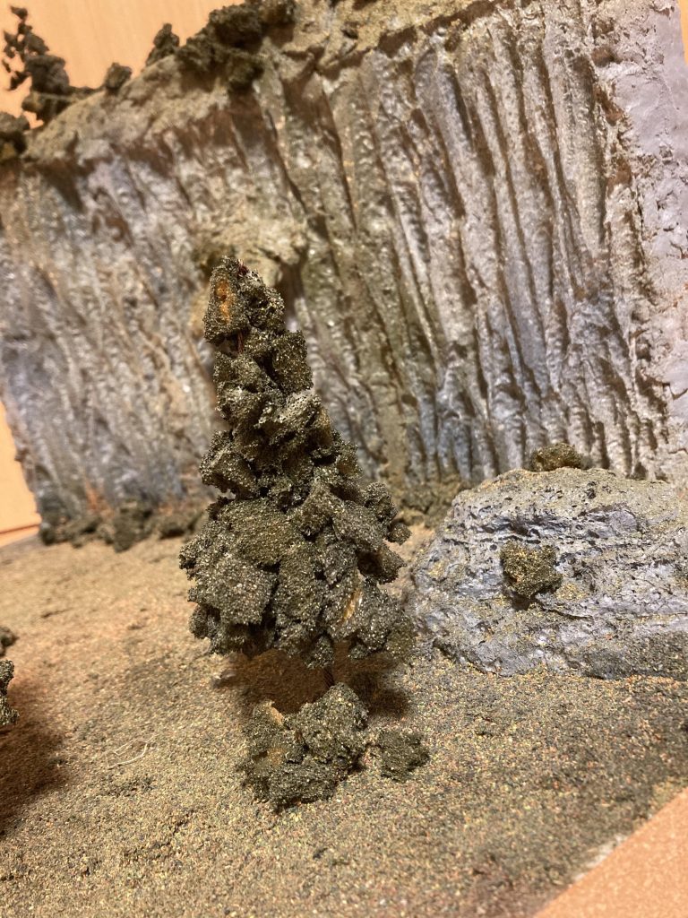 岩肌は発泡スチールにはんだゴテで縦にランダムに溶かしてそれっぽく木は銅線にスプレー糊で小さくちぎったスポンジをくっつけて木を表現