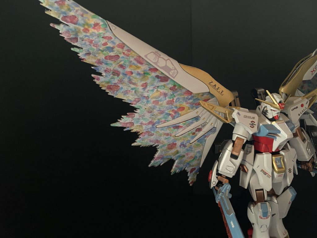 本作の目玉!光の翼もともとのラメ入り蛍光ピンクのエフェクトを、偏光仕上げにしようか、クリアグラデーションにしようか、色々迷った末、このように完成しました。薄いシルバー下地の上に、赤、青、緑、黄のクリアカラーを筆で羽の一枚一枚を描き出すように彩色。仕上げにパールコート+クリアコート。水性塗料の特徴を活かした、水彩画のような柔らかく淡いタッチです。