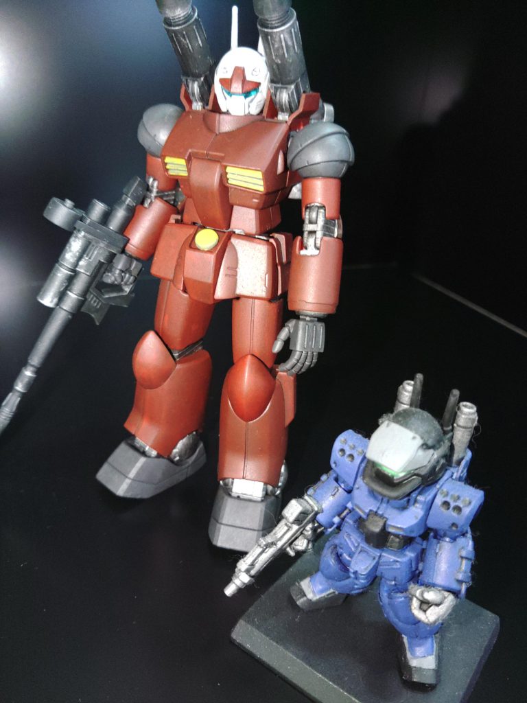 最後は食玩のガンキャノンⅡ(シタデルカラーで青にリペイント)と一緒に。塗装工程&使用塗料クレオス水性サフタミヤアクリルカラー ハルレッドで赤部分と黄部分と間接を塗装タミヤアクリルカラー レッドで赤部分を薄めに目的の色になるまで塗装~乾燥繰り返し(しっかり赤を発色させない程度に)タミヤエナメル塗料 ブラック+レッドブラウンで赤部分のみウォッシングクレオス水性ホビーカラー ダークグレーでキャノン砲とライフルを塗装タミヤアクリルカラー ジャーマングレーで肩と足の付け根部分を塗装クレオス水性ホビーカラー 黒鉄色で間接部分とバックパックを塗装タミヤエナメル塗料 フラットアルミでキャノン砲、ライフル、肩と足の付け根、間接部分とバックパックをウォッシングタミヤアクリルカラー イエローで塗装タミヤアクリルカラー ホワイトで頭部を塗装タミヤエナメル塗料 グレーで頭部、黄部分をウォッシング最後に水性トップコート艶消しでコーティング顔のクリアーパーツは何も手を加えず使用長々となりましたが以上です。