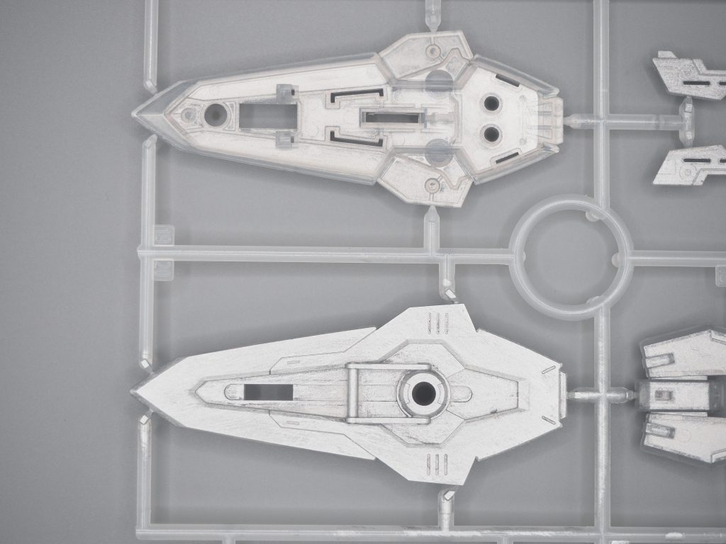 アクリジョンのシルバーは水分が多いのか、なかなかクリアパーツに載りません。今回は塗装に先だって、水性プレミアムトップコート (つや消し)を吹きました。これで表面がやや凸凹するため、アクリジョンシルバーが載りやすくなりました。上の写真が裏側をシルバー塗装した状態。下の写真は表面も薄くシルバー塗装した状態です。下は、ほかの部位よりも、アクリジョンがよく載っています(今回のキットのなかでは、厚く塗装しすぎた)。トップコートをサフとして使った場合の効果と見て頂ければ。