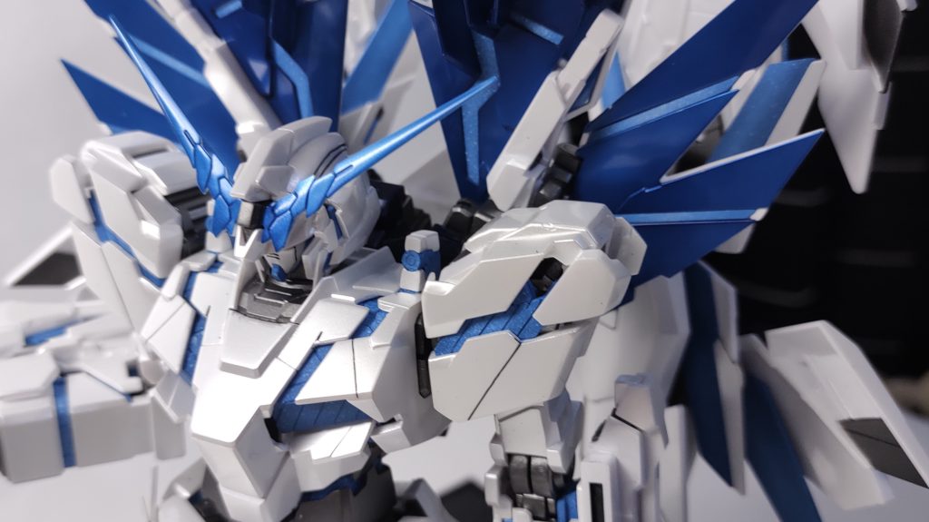 本体の白は、白＋パープル少量→雲母堂本舗のビスマスパール→クリアコートアンテナやアームドアーマーXCのブルーメタリックは、ビスマスパールのあとにディープクリアブルーで色を付けました。つま先などの紺色は、クレオスのサファイアブルーとブラックを4：1で混ぜたのを塗っています。フレームやメカ色は、ガイア スターブライトアイアン、ハイパービームジャベリンのグレーはスターブライトアイアン＋スターブライトシルバーで、どちらも半ツヤにしました。