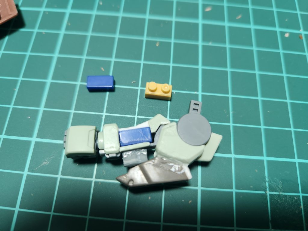 腕の改造部分肘部分のストッパーをカットして開閉ギミックを有効化肘を開いたときに装甲が不自然な形になるのでプラ板で延長肘の装甲にカバーを追加(多分フレームアームズのジャンク)上腕にプラ片を接着、ピンバイスで穴をあけてビームサーベルの刃が挿せるように上腕に四角い穴を開けて100均のブロックを接着、凹凸のないブロックでカバーを作成シールドや武装にブロックの受けを接着することで簡単に固定できるかなと思い実施、なかなかいい感じ