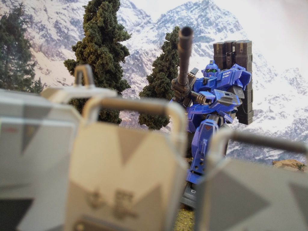 今回データ収集する武装は、180mmキャノン。分解状態でコンテナに入っており、射撃地点で組み立てて使用する。山間の高地から敵基地を遠距離狙撃する。…が、狙撃という程の射程距離は無く、消音機構も無い。一射目で砲撃方向に気付かれる可能性が充分にあり、相手MSの性能や練度に依っては接近されるのも早いだろう。取り回しが悪く連射が効かない。…好みの武器では無いが仕方ない…また今回使用するウェポンコンテナとシールドには都市迷彩が施されているが、雪山を背にする射撃ポイントで遮蔽陣地を作り雪中迷彩効果を狙う事もプランの内だ。