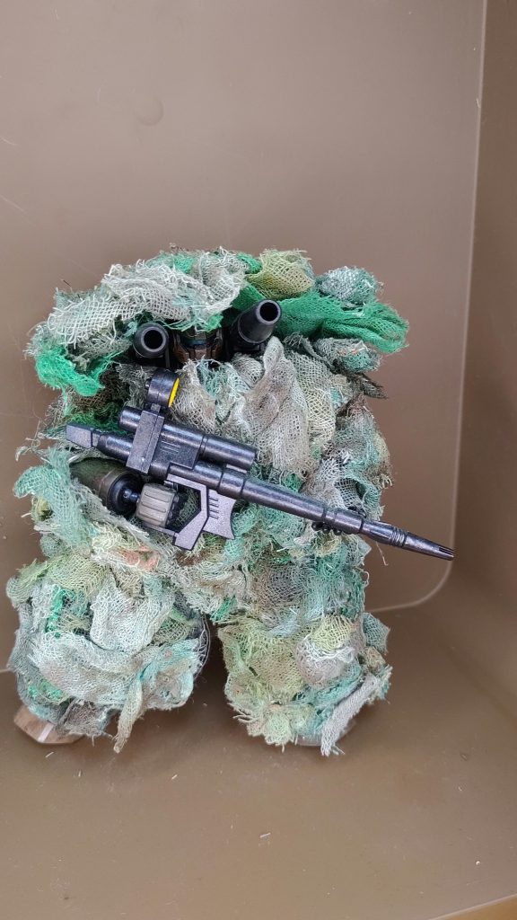 100均のガーゼと、水彩絵の具でギリースーツを自作しました。有視界戦闘なら、偽装でMSの輪郭がくっきりしないように、また山の多い日本の地形に合わせて製作しました。